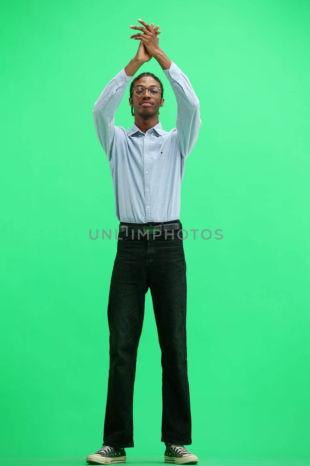 A man in a gray shirt, on a green background, in full height, claps by Prosto