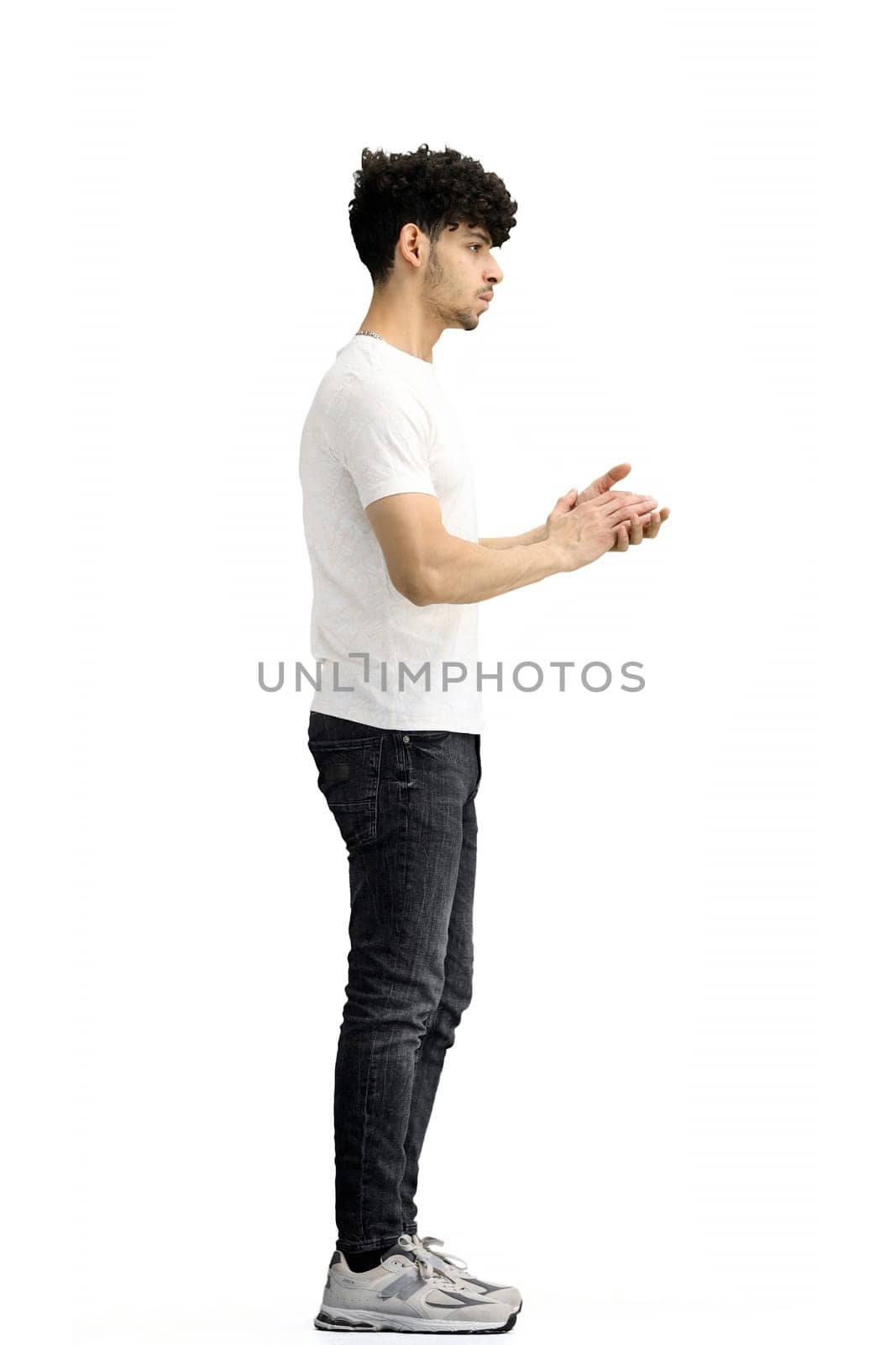 A man, on a white background, in full height, claps.