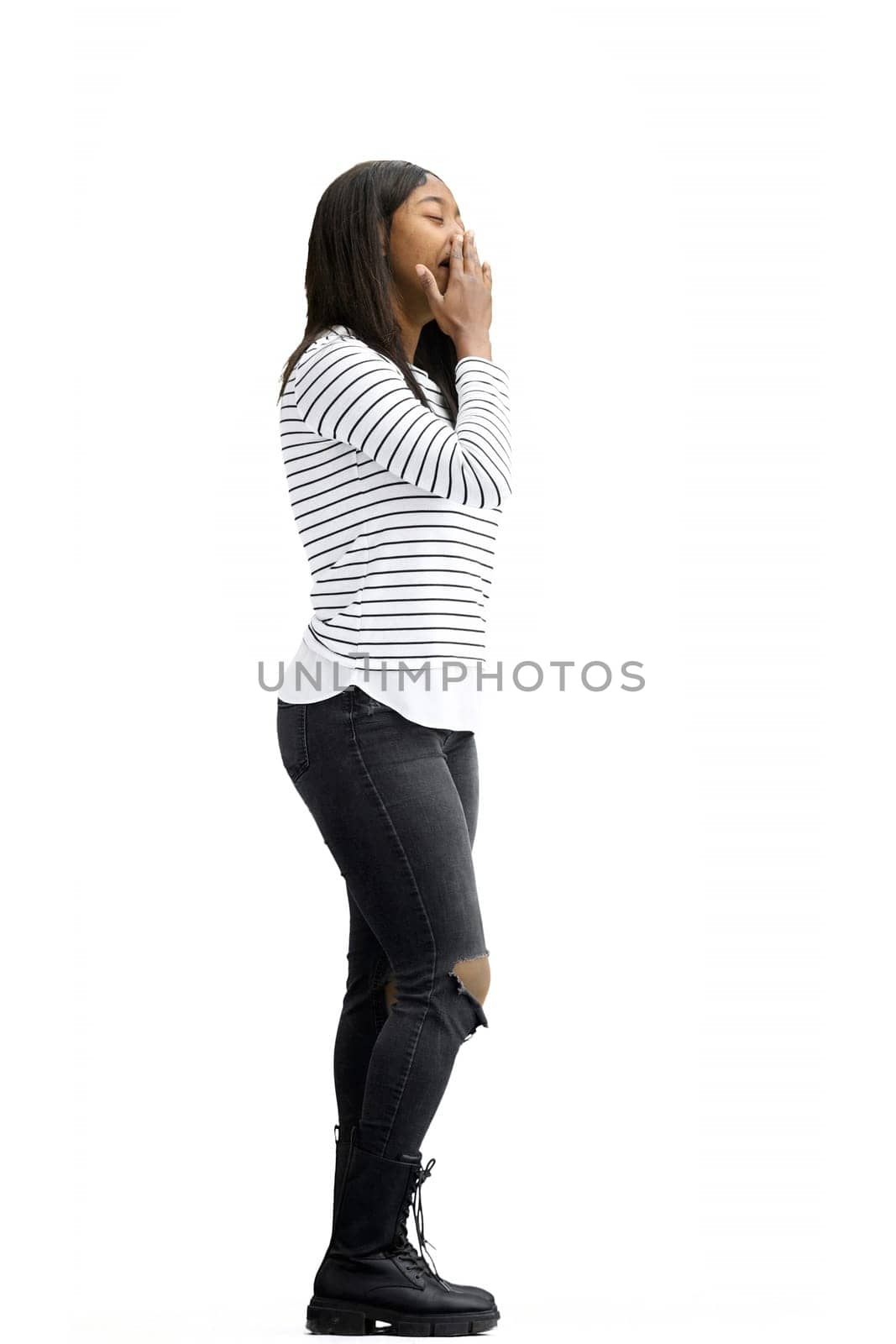 A woman, on a white background, in full height, yawns.