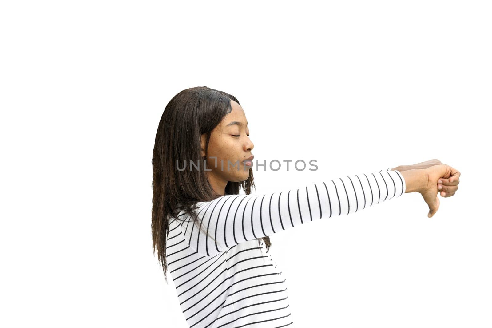 A woman, on a white background, in close-up, shows her thumbs down.