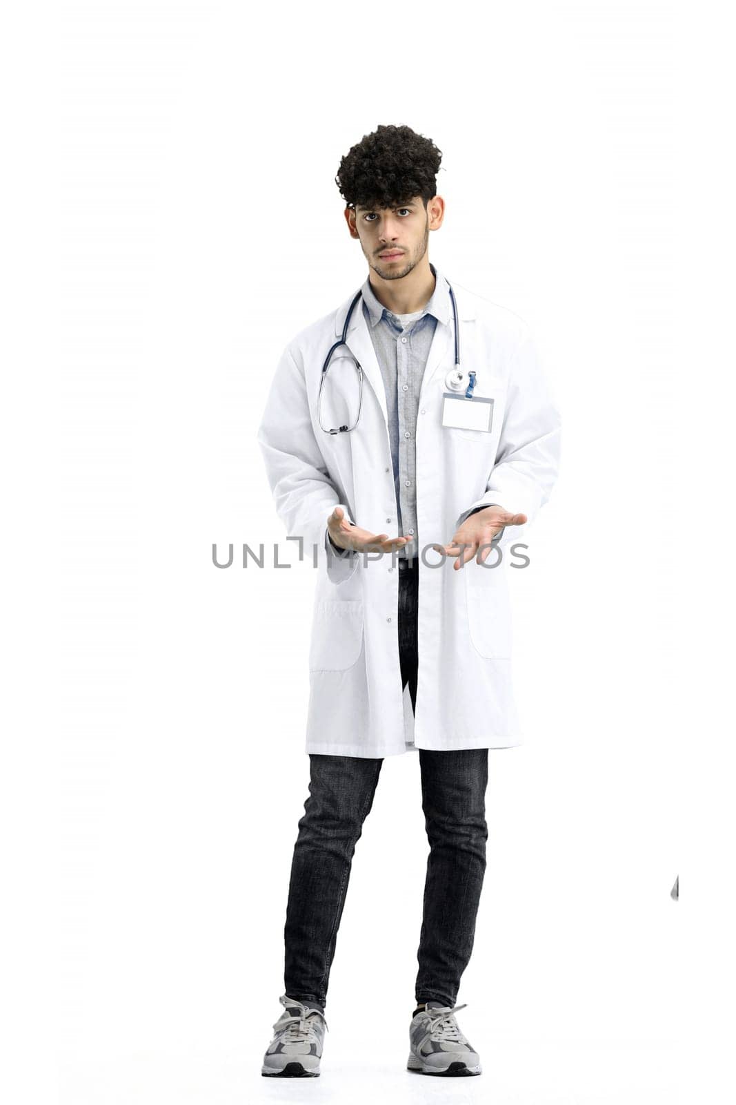 A male doctor, full-length, on a white background, spreads his arms.