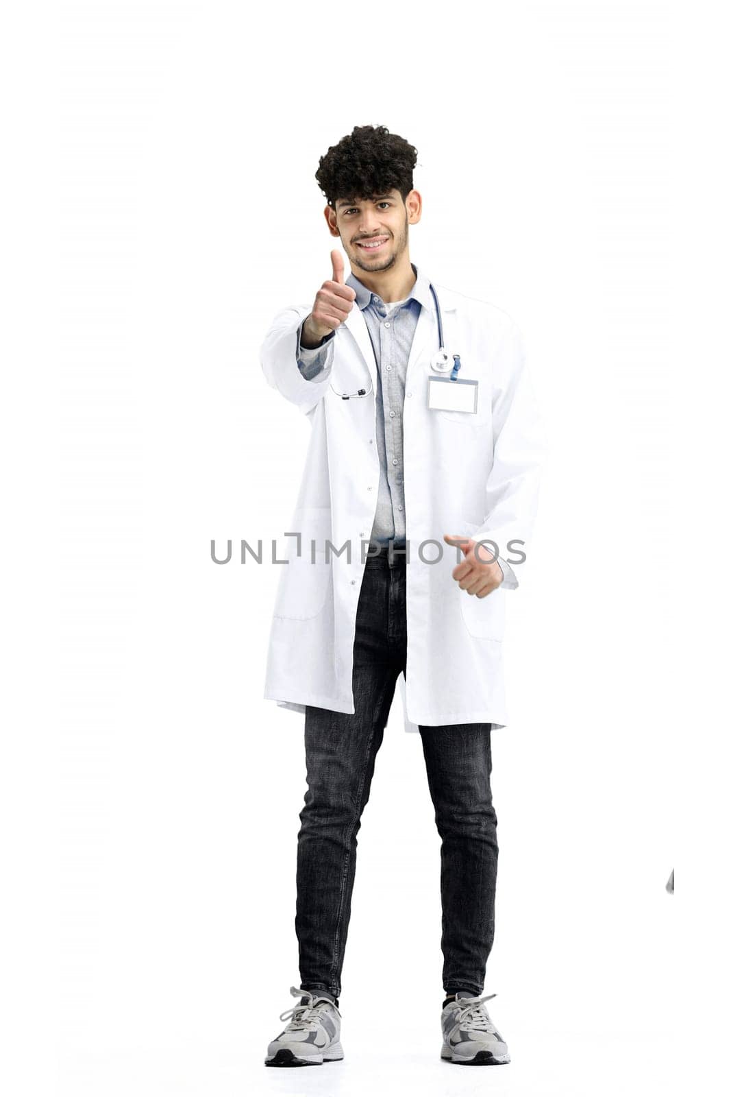 Male doctor, full-length, on a white background, shows his thumbs up.