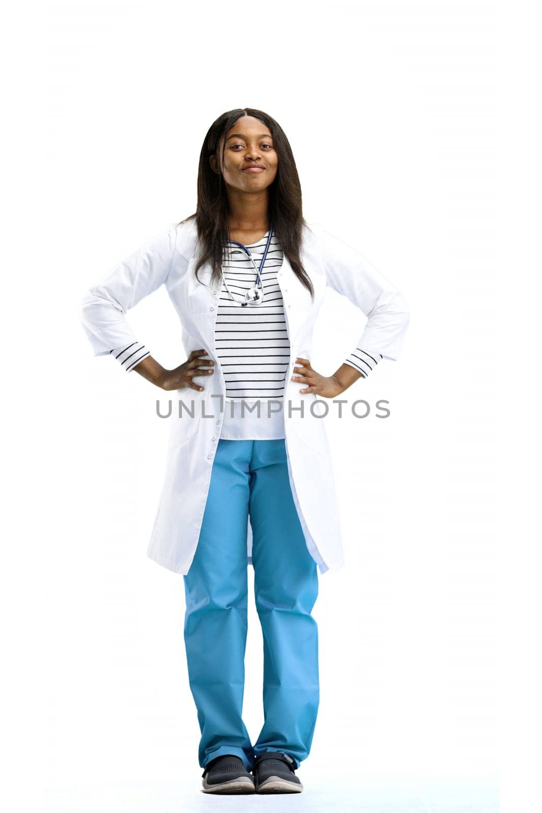 Female doctor, on a white background, full-length, hands on hips.