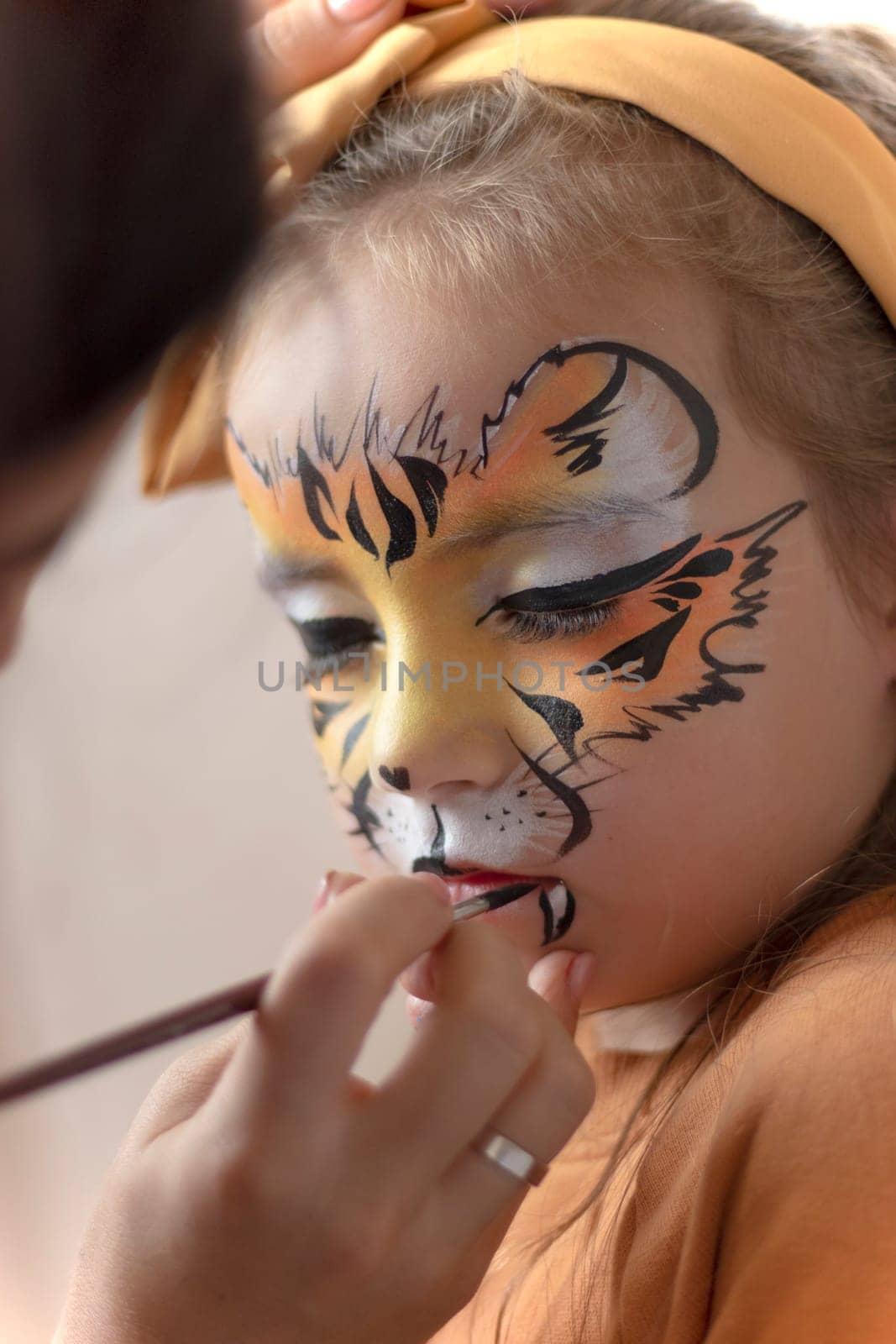 Cute makeup little tiger. girl getting face painting outdoors, by Suietska