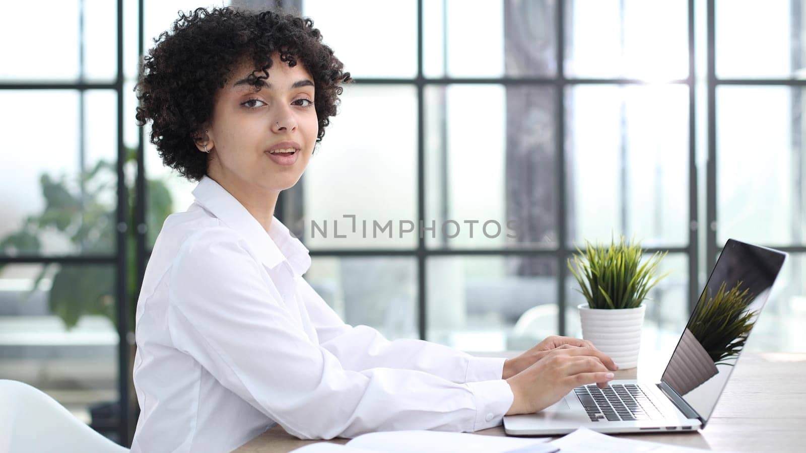 Portrait of Young Successful Caucasian Businesswoman Sitting at Desk Working on Laptop by Prosto