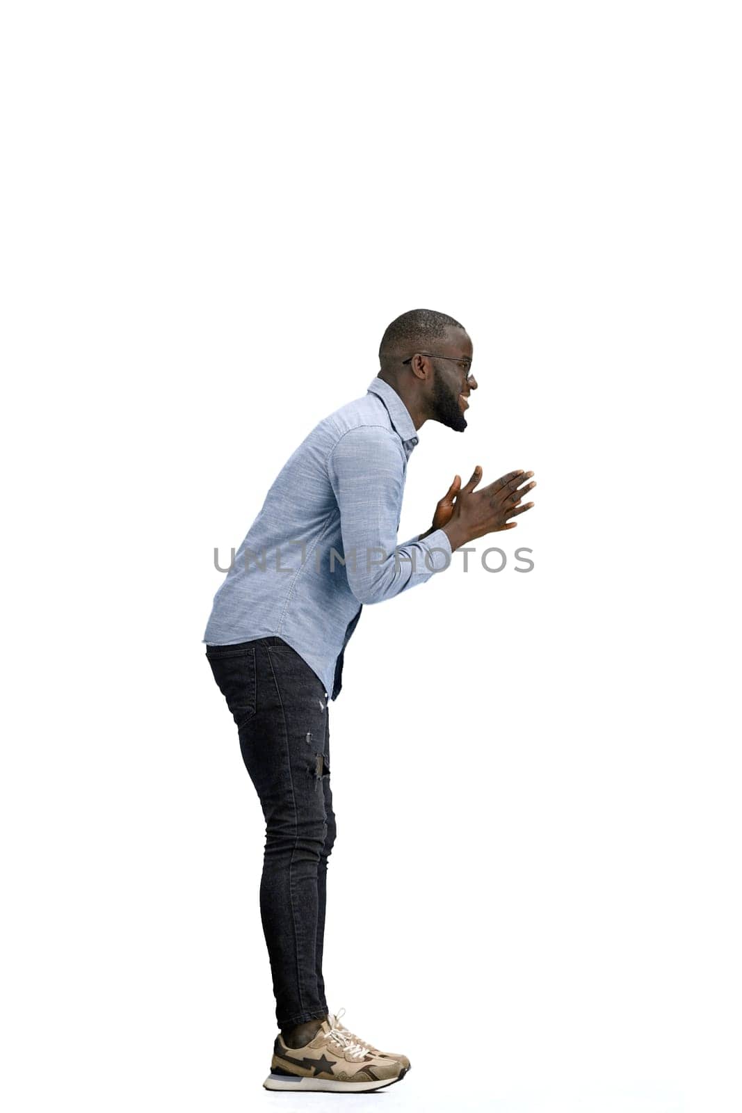 A man, full-length, on a white background, rubs his hands.