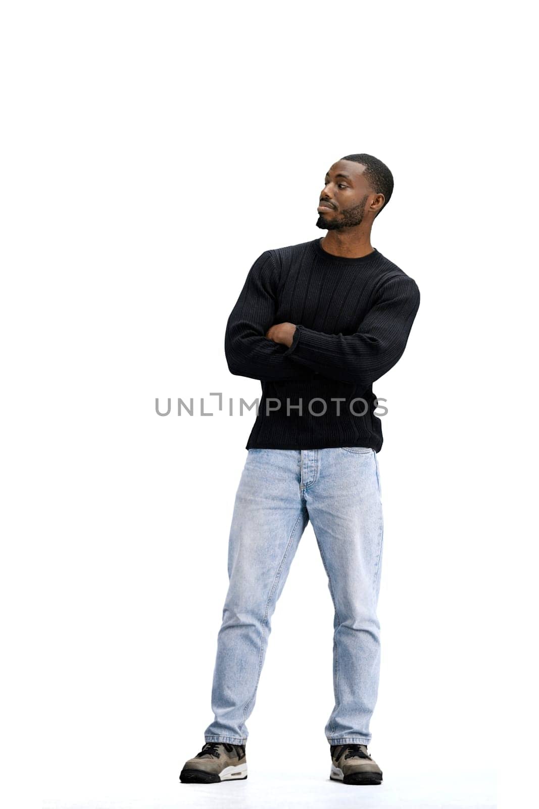 A man, full-length, on a white background, crossed his arms.