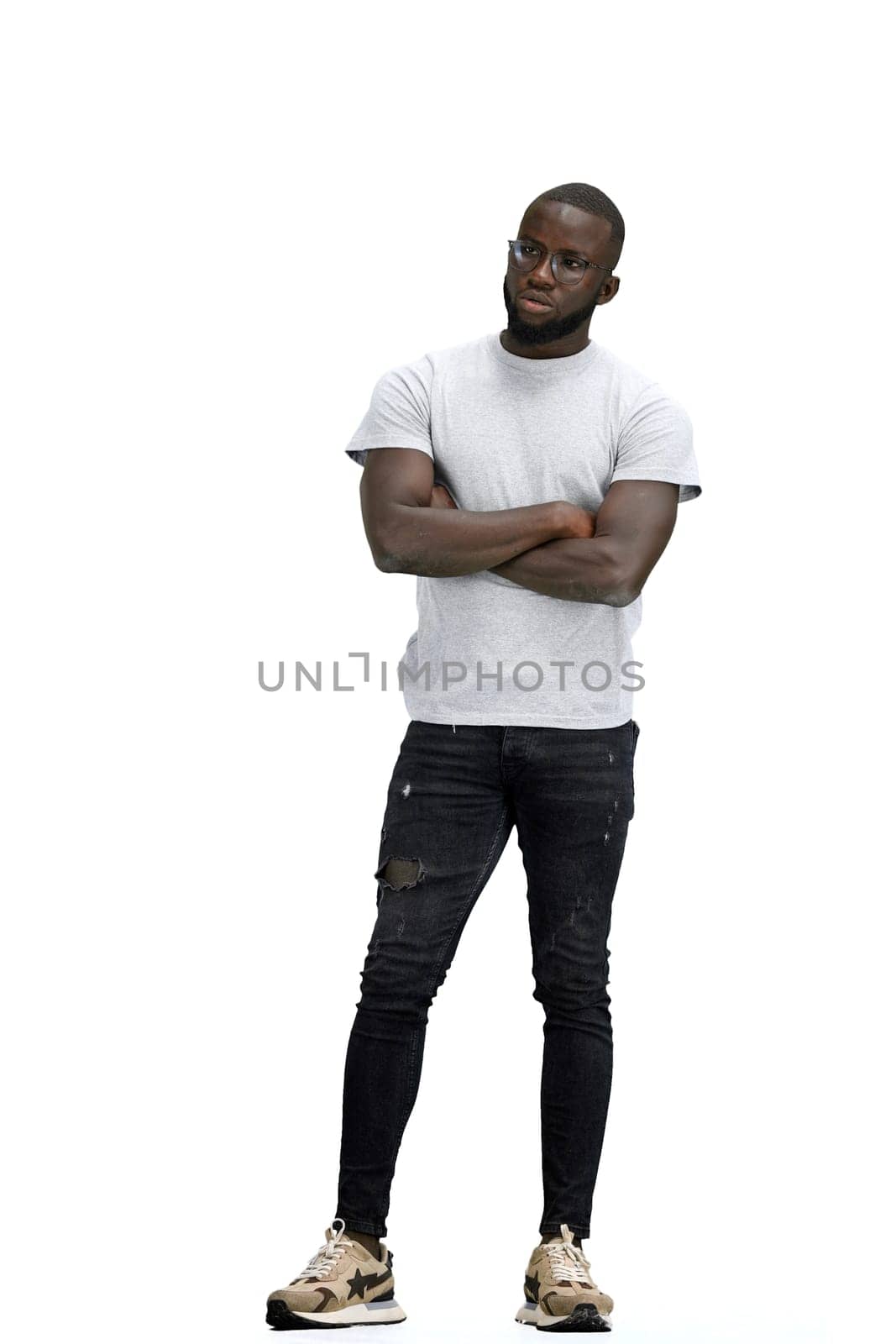 A man, full-length, on a white background, crossed his arms.