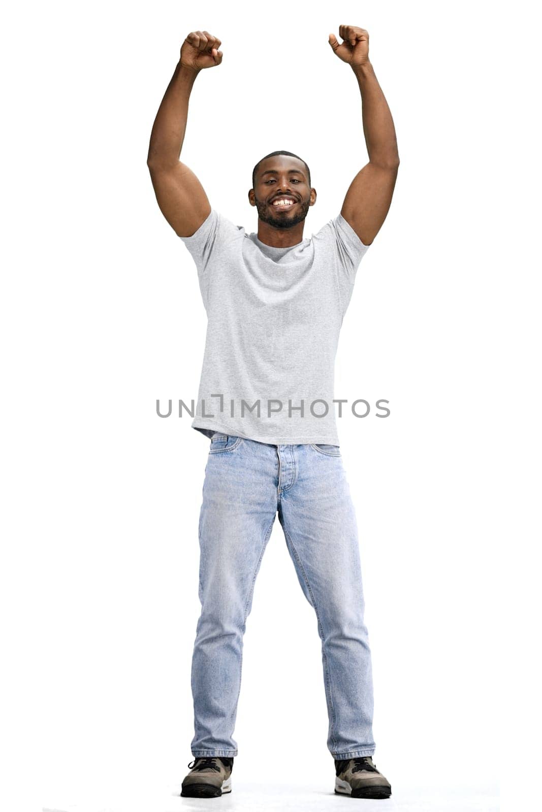 A man, full-length, on a white background, raised his hands up.