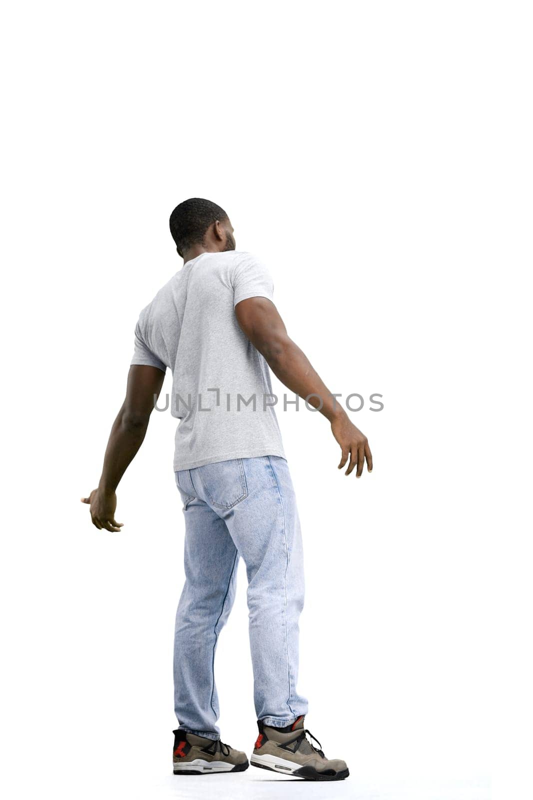 A man, full-length, on a white background, spreads his arms.