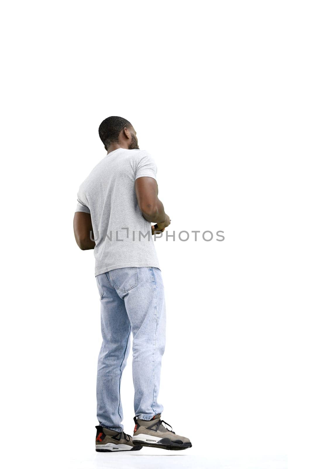 A man, full-length, on a white background, uses a phone.