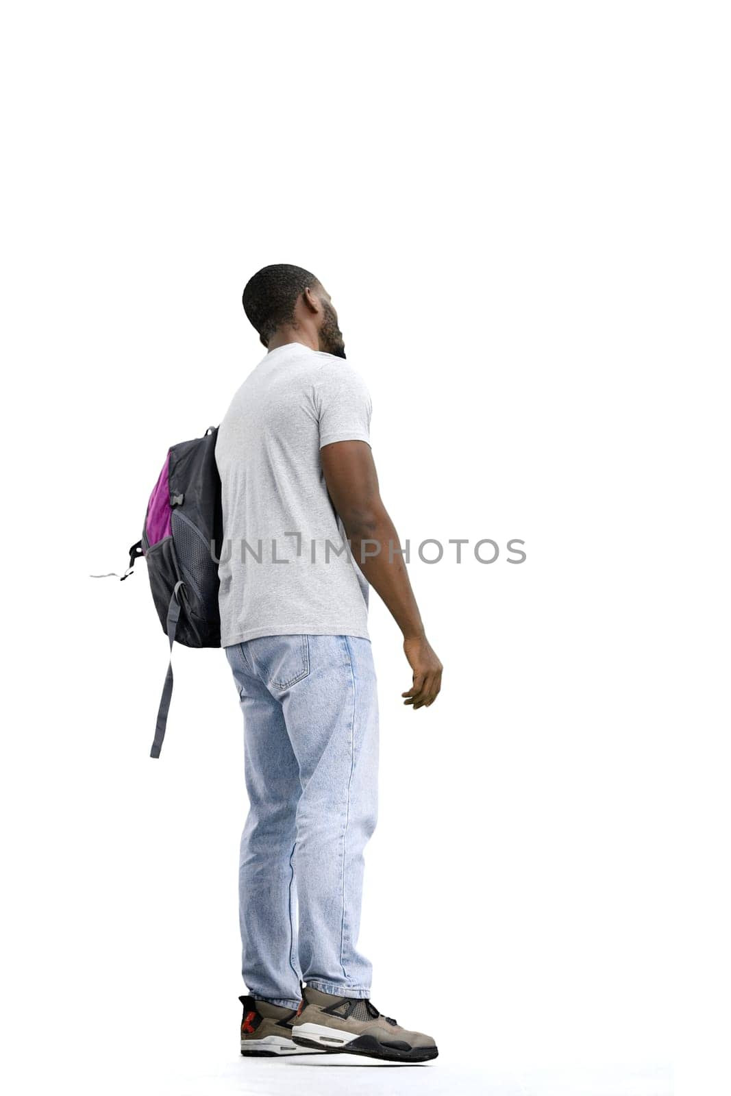 A man, full-length, on a white background, with a backpack.