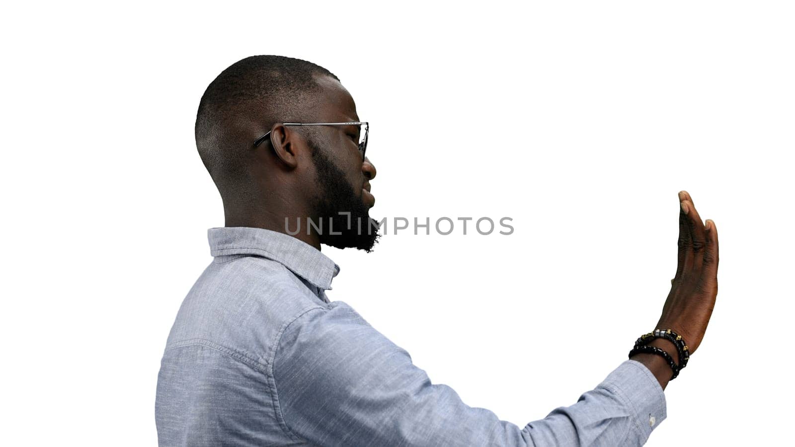 A man, close-up, on a white background, shows a stop sign.