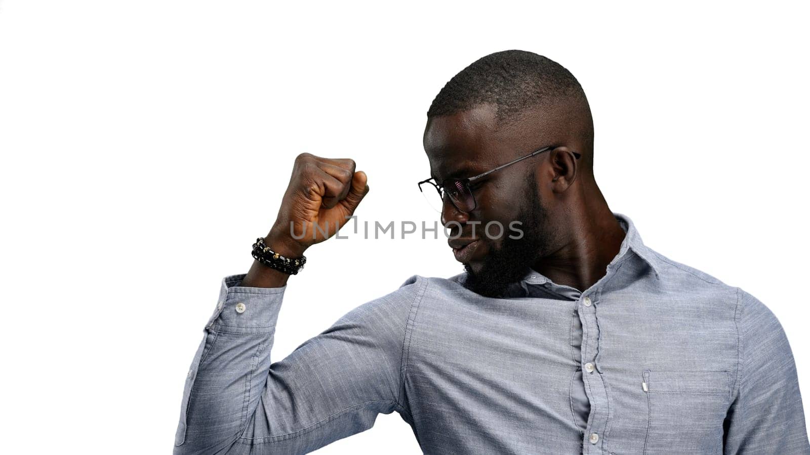 Man, close-up, on a white background, shows strength.