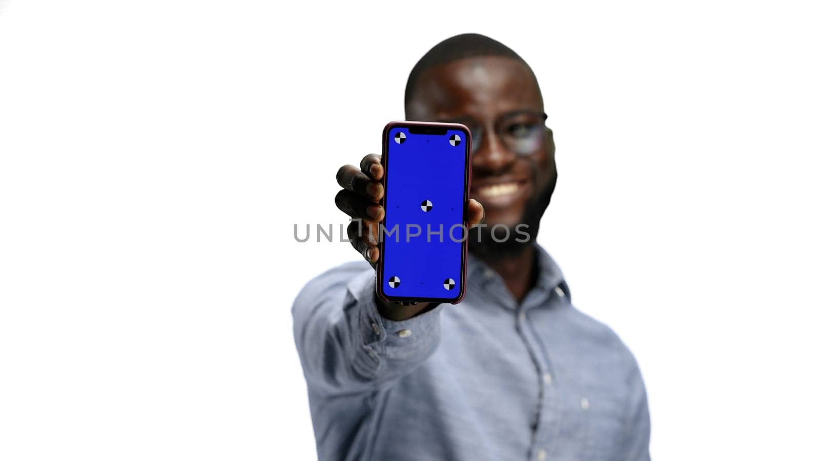 A man, close-up, on a white background, shows a phone.