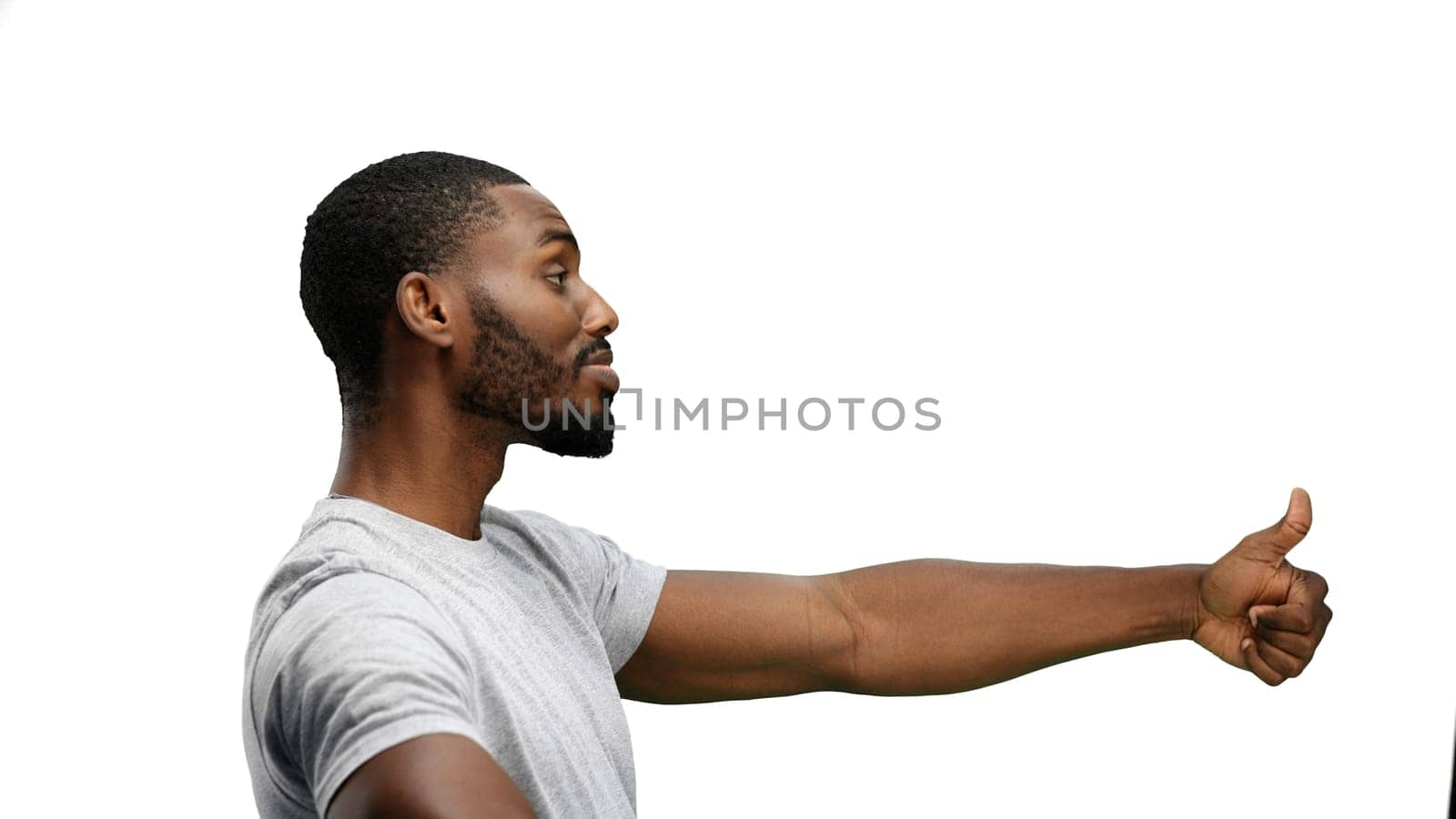 A man, close-up, on a white background, shows his thumbs up.