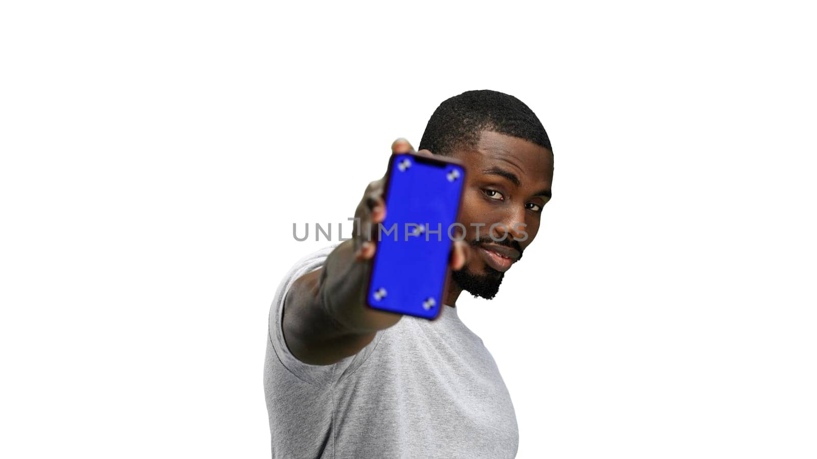 A man, close-up, on a white background, shows a phone.