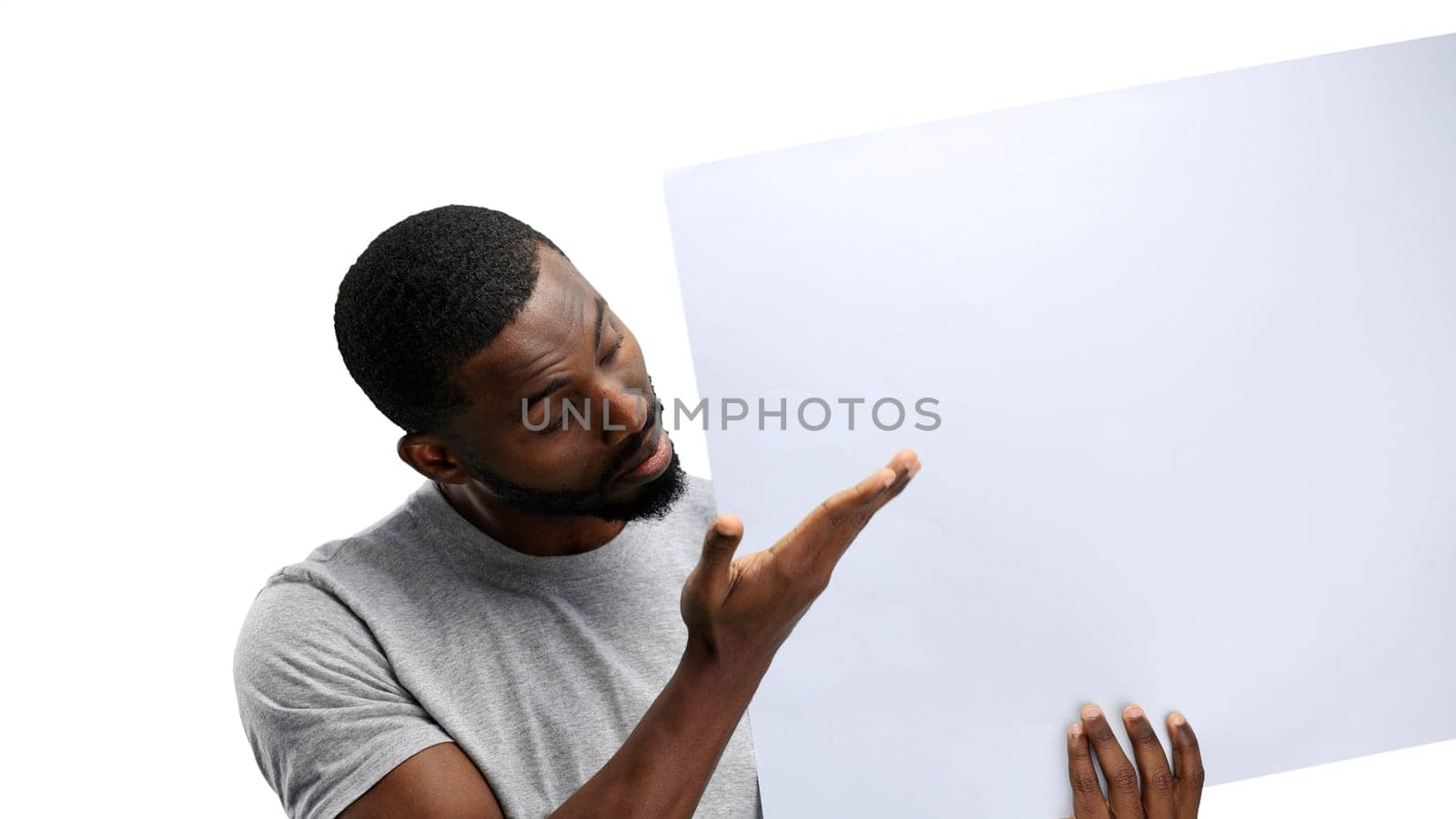 A man, close-up, on a white background, shows a white sheet.