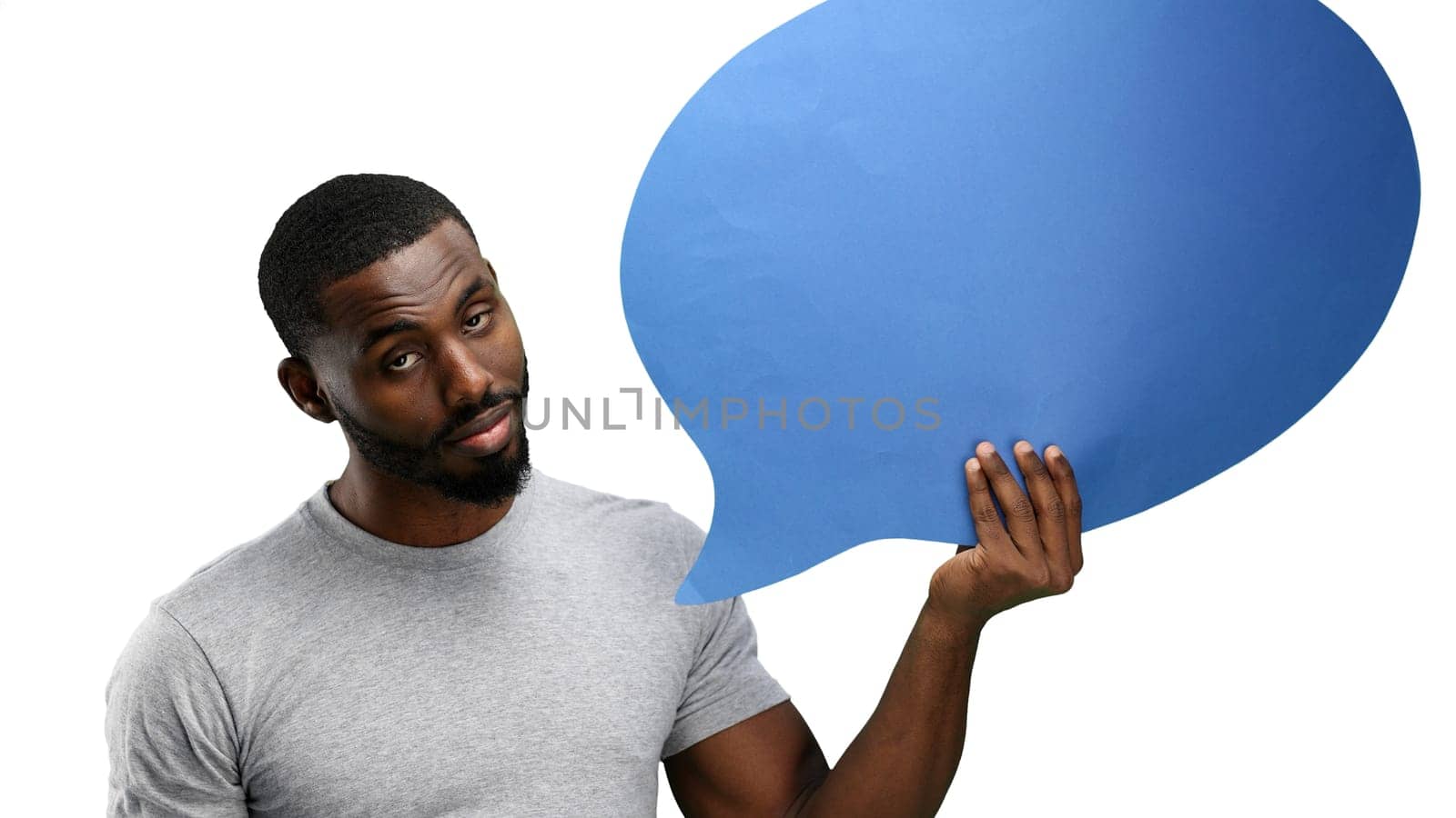 A man, close-up, on a white background, shows a blue comment sign by Prosto