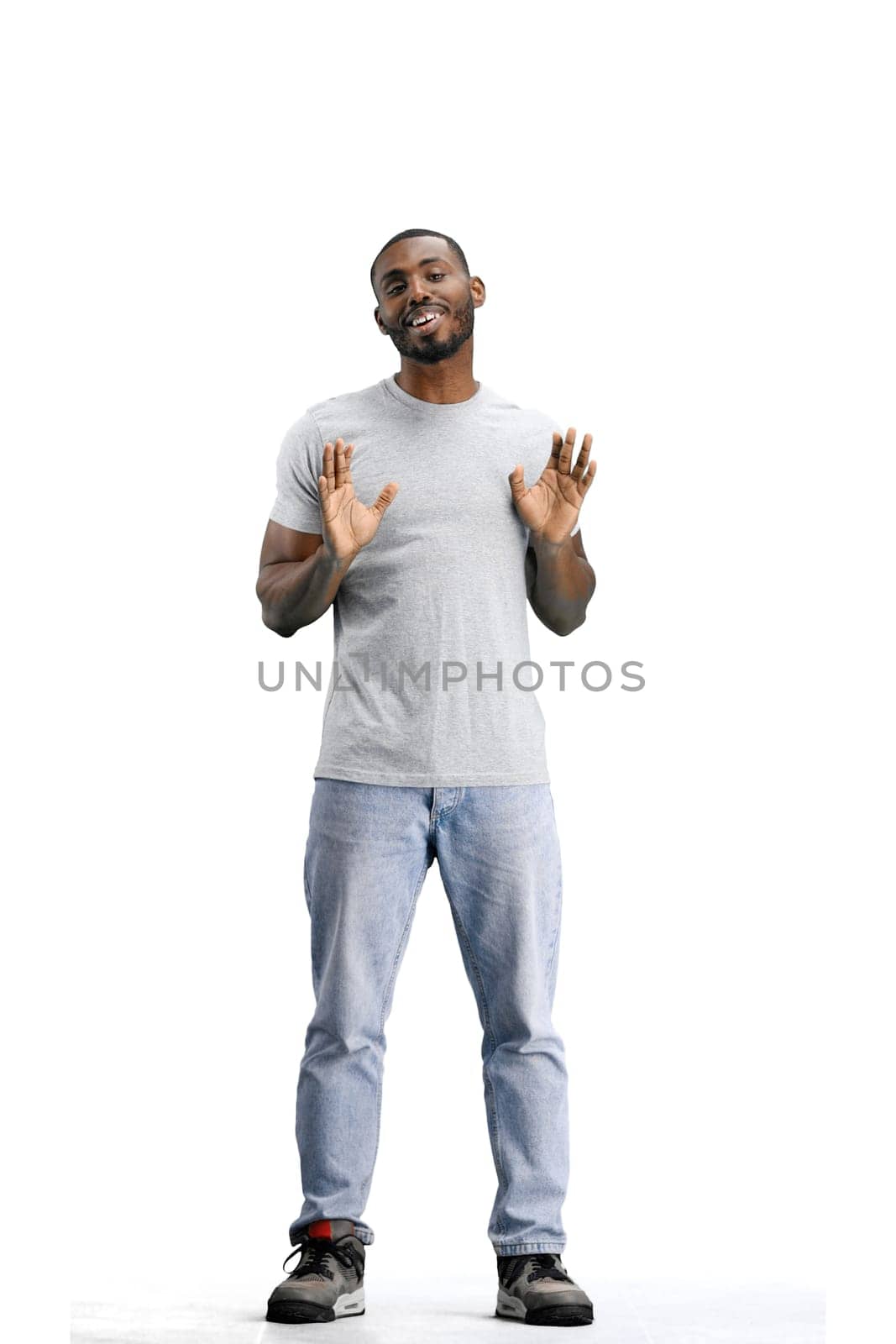 A man, full-length, on a white background, raises his hands.