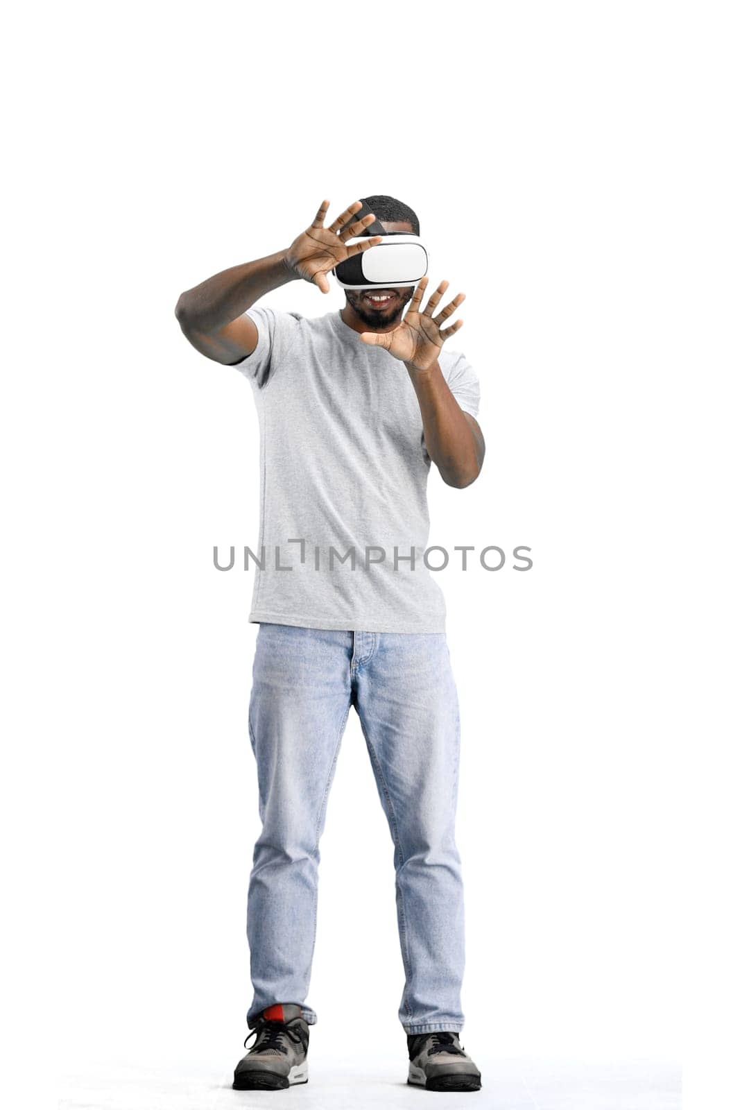 Man, full-length, on a white background, wearing VR glasses.