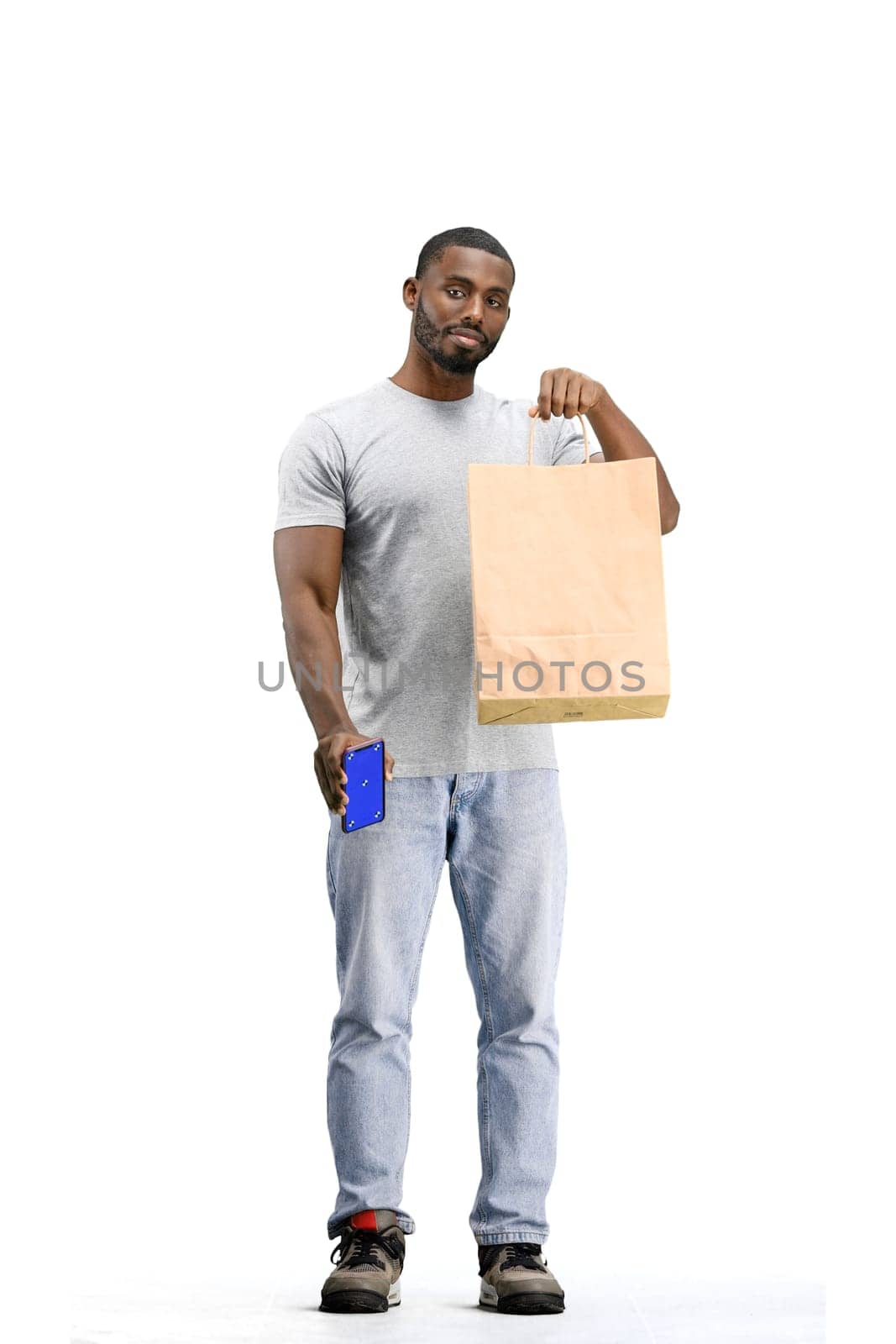 A man, full-length, on a white background, with bags and a phone.