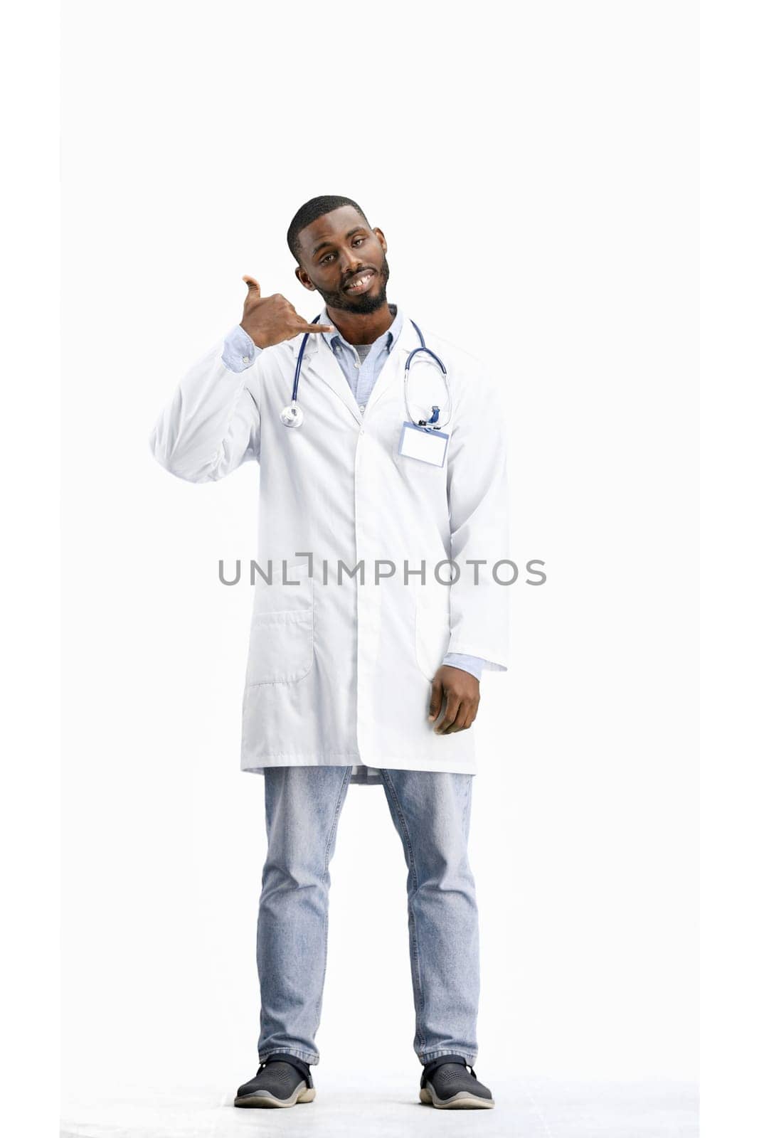 The doctor, in full height, on a white background, shows a call sign by Prosto