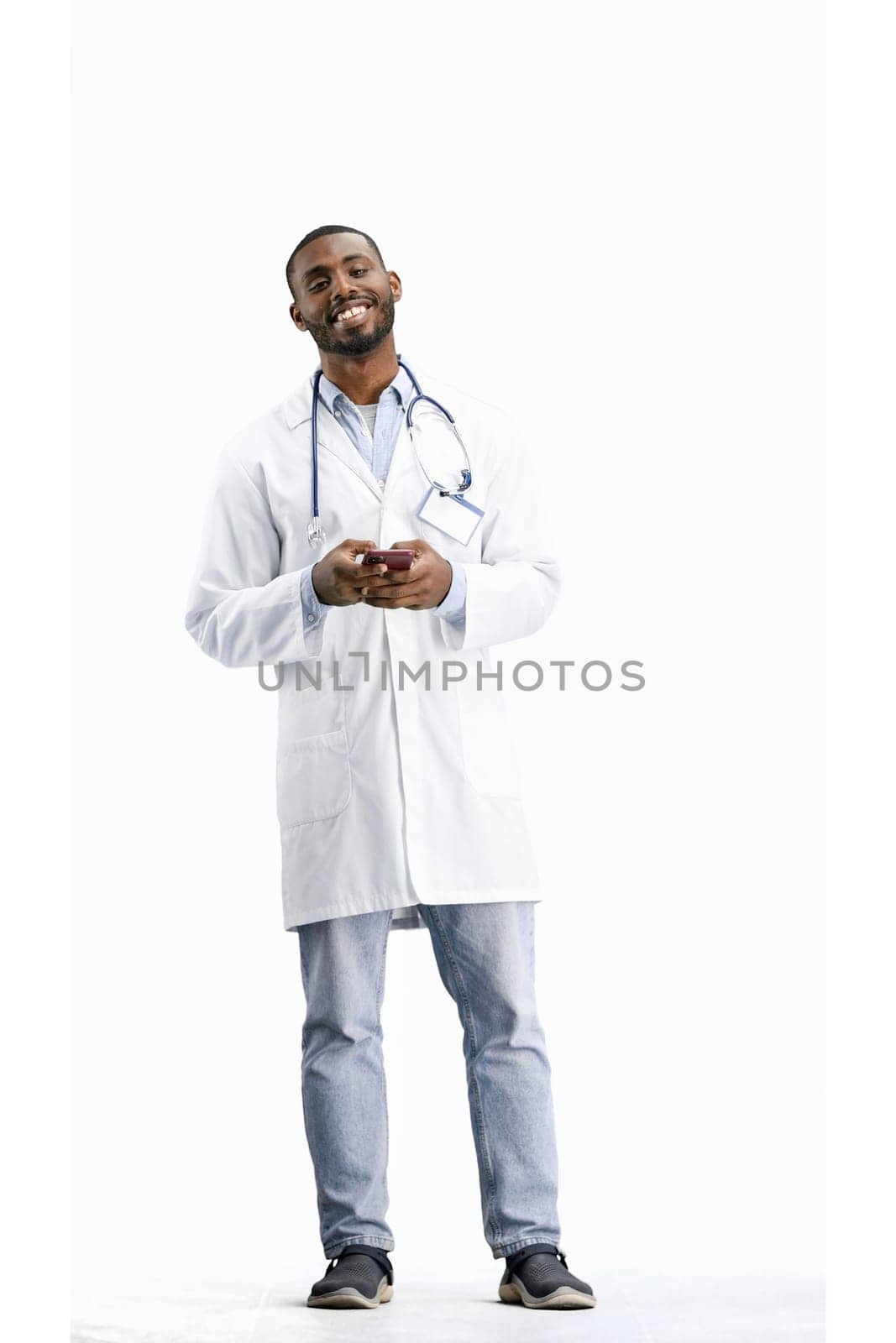 The doctor, in full height, on a white background, talking on the phone.