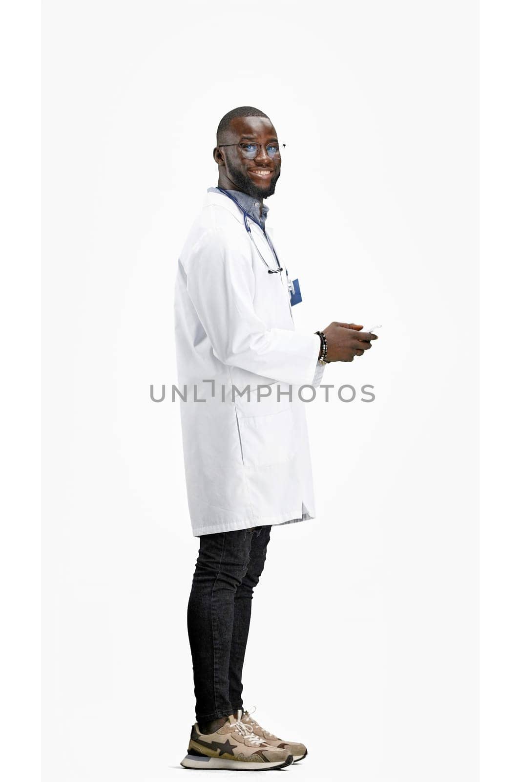 The doctor, in full height, on a white background, talking on the phone.