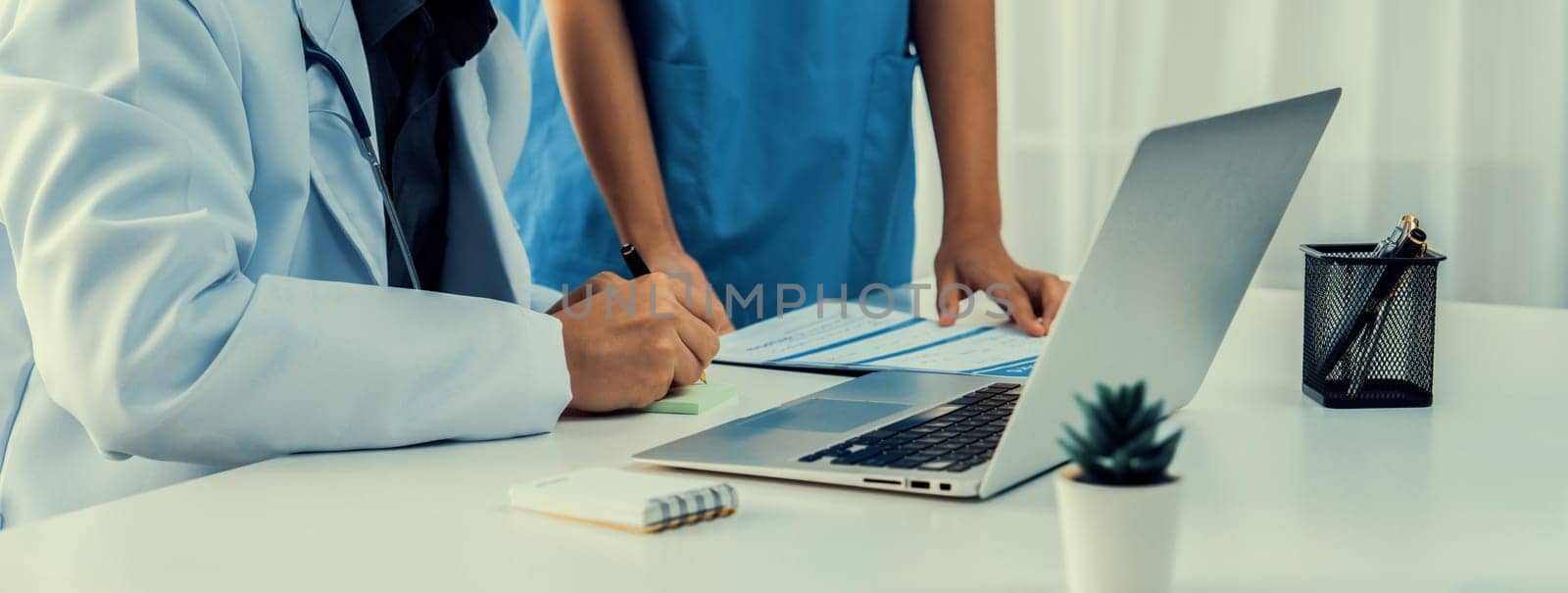 Professional various team of medical working and planning medical treatment at hospital table together. Teamwork lead to successful illness and sickness treatment. Panorama Rigid