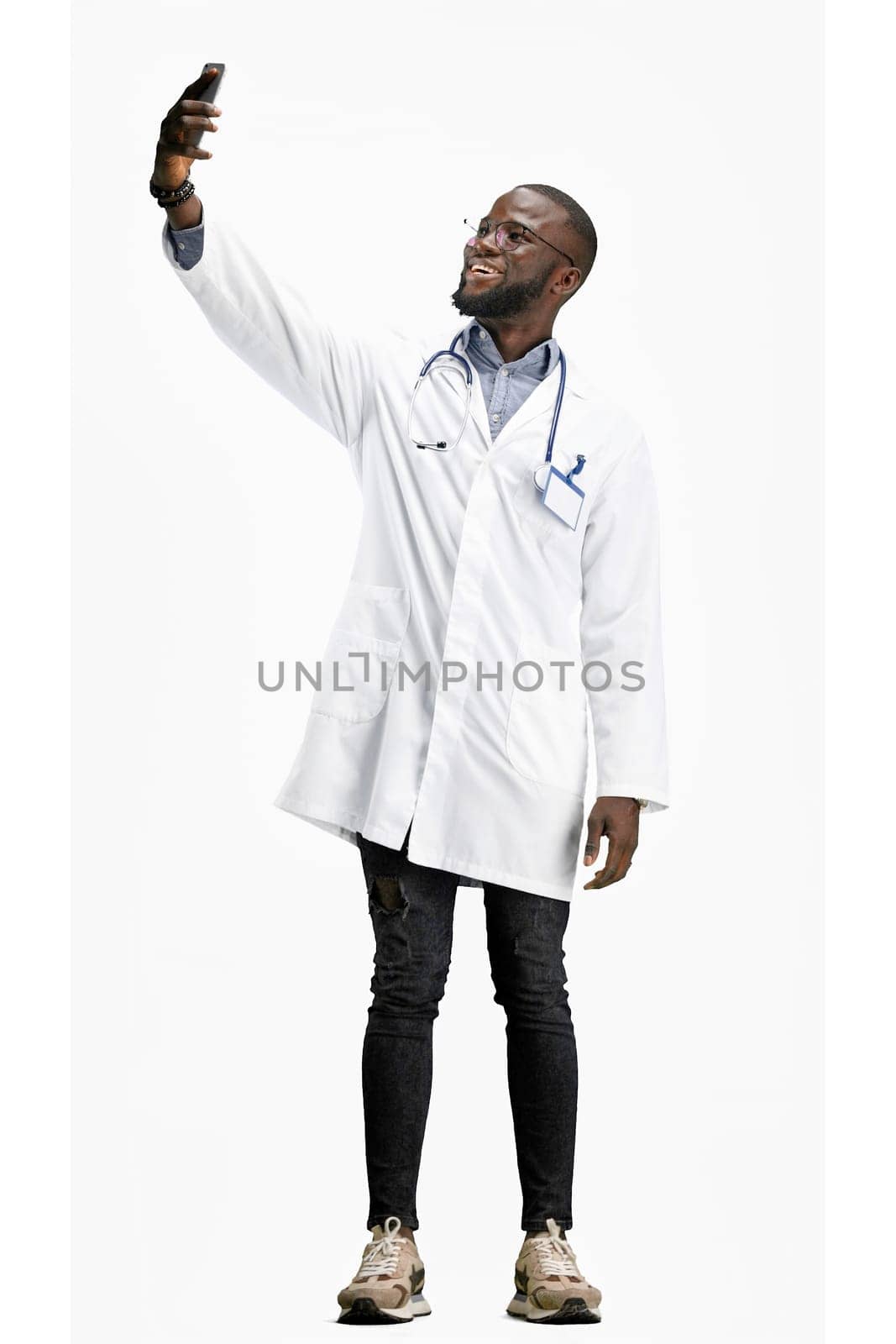 The doctor, in full height, on a white background, talking on the phone by Prosto