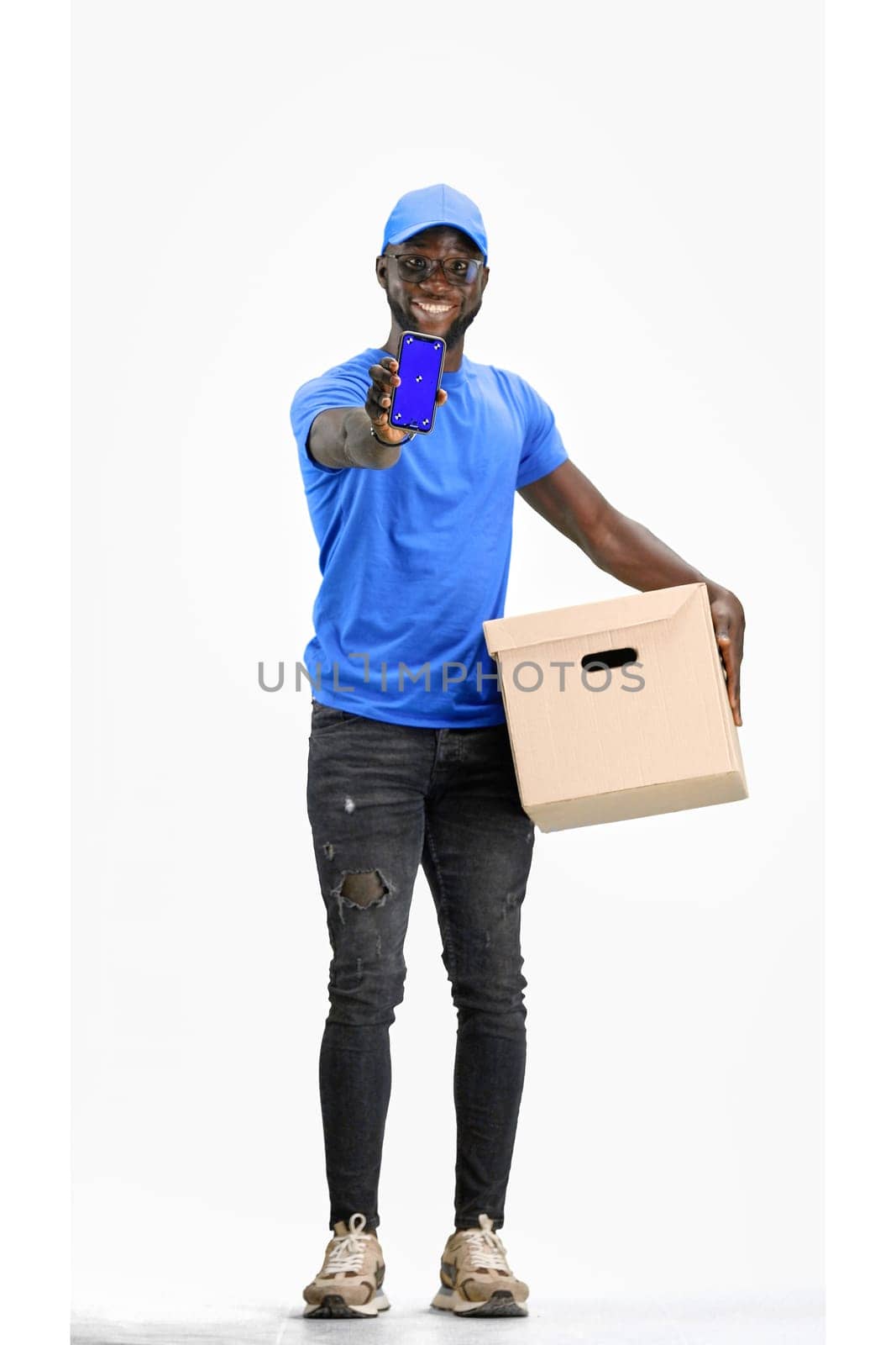 The deliveryman, in full height, on a white background, shows the phone by Prosto
