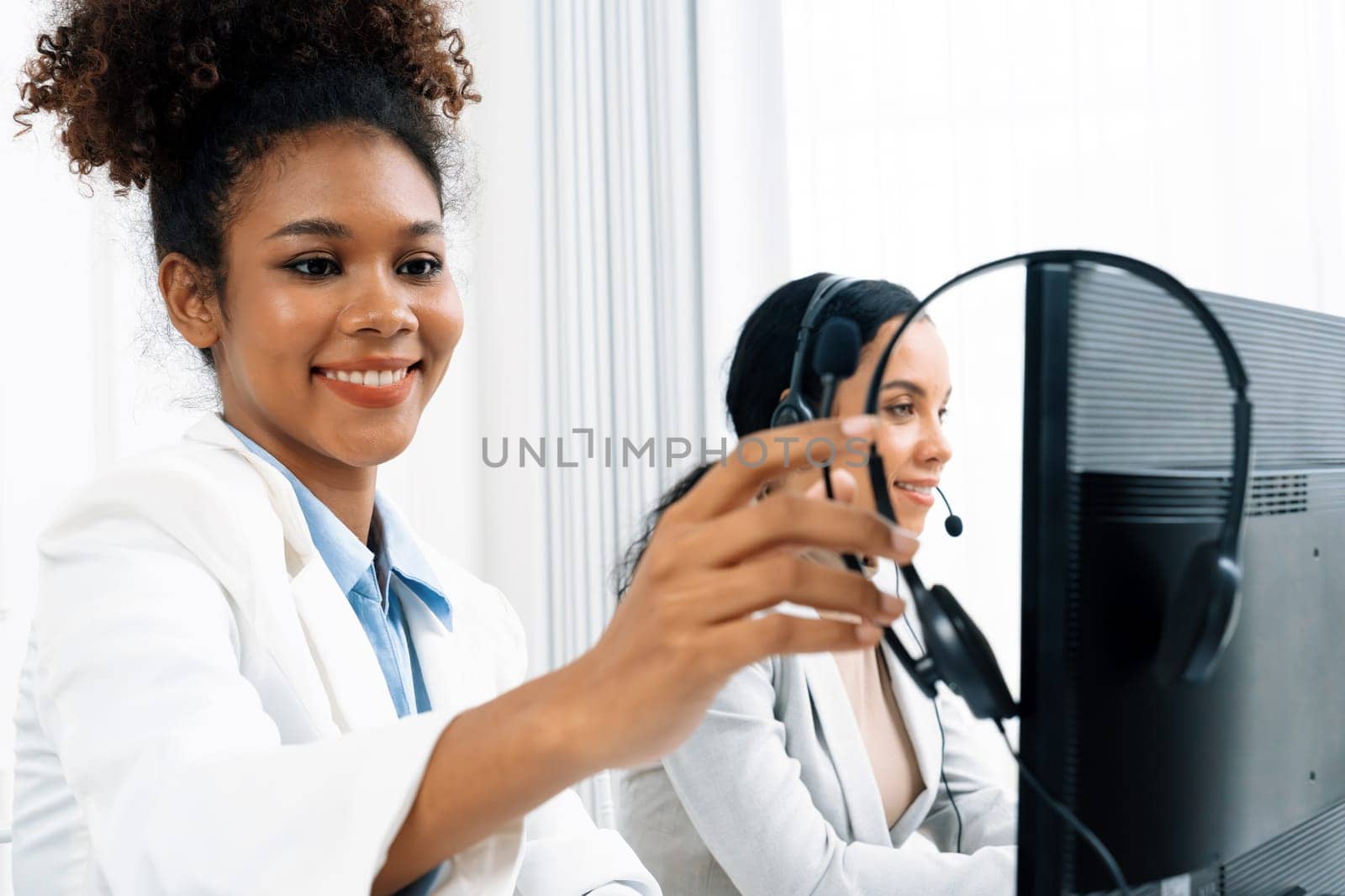 African American businesswoman wearing headset working in office to support remote crucial customer or colleague. Call center, telemarketing, customer support agent provide service on video call.