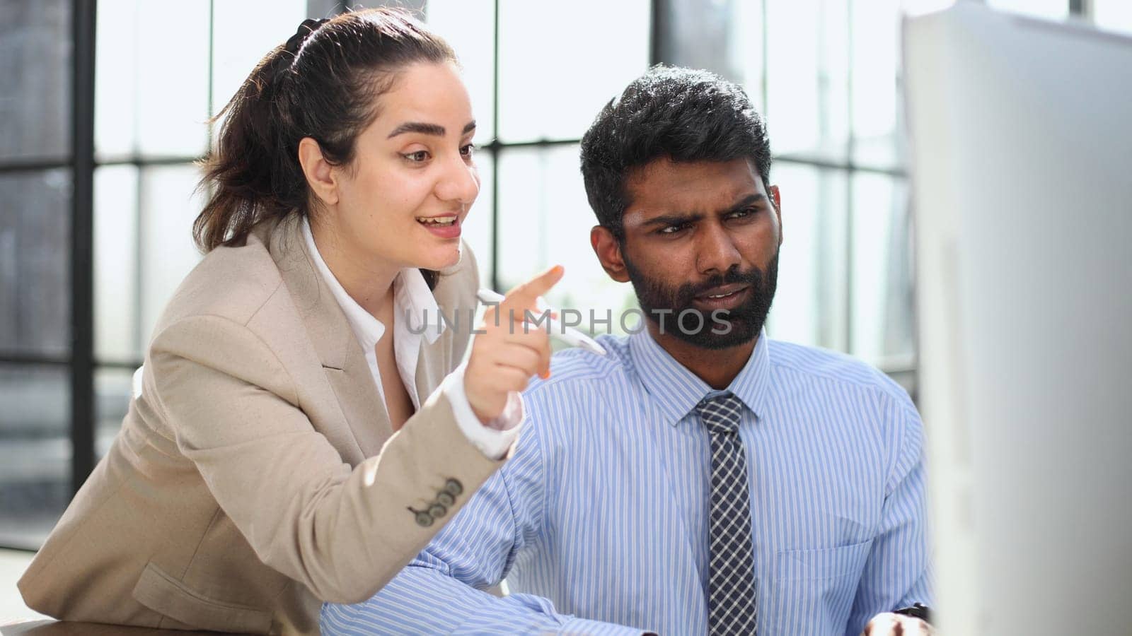 colleagues discussing project while working with laptop in office indoors