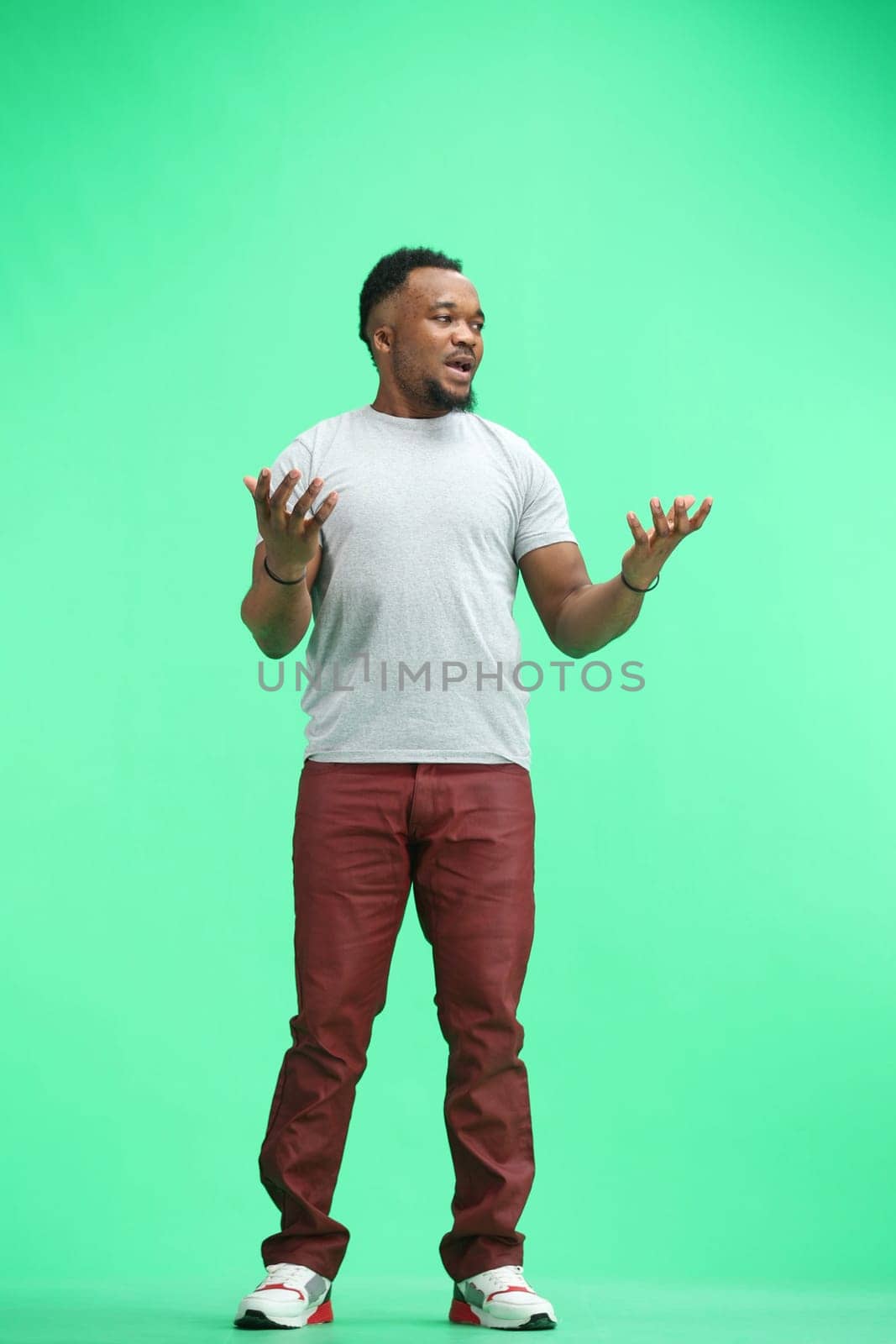 Man, full-length, on a green background, spreading their hands by Prosto