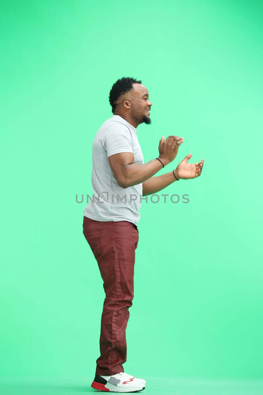 A man, full-length, on a green background, clapping by Prosto