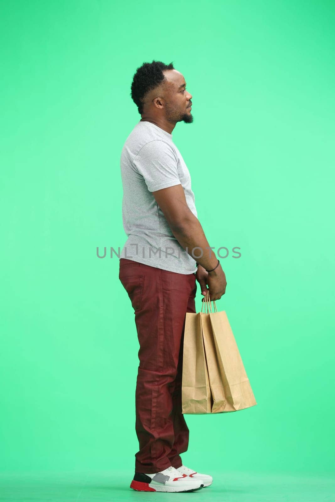 Man, full-length, on a green background, with bags by Prosto