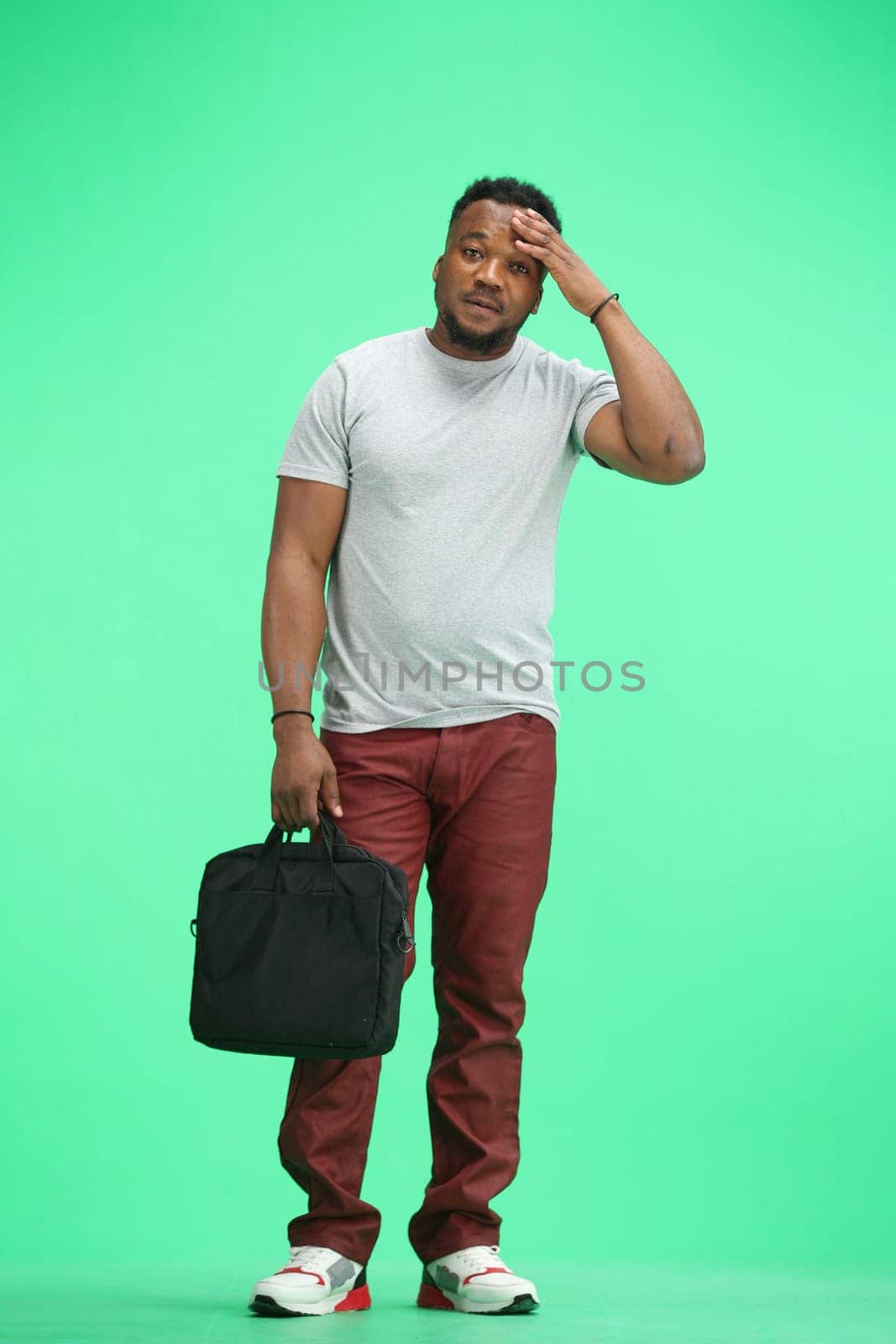 Man, full-length, on a green background, with a briefcase by Prosto