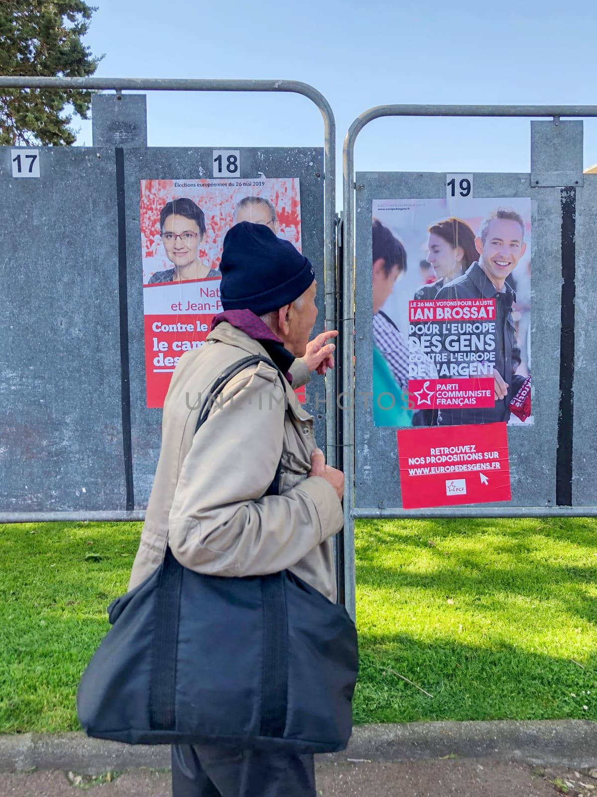 DIEPPE, FRANCE - MAY 15, 2019 : Man looks at the banner with candidates for elections to the European Union by Godi