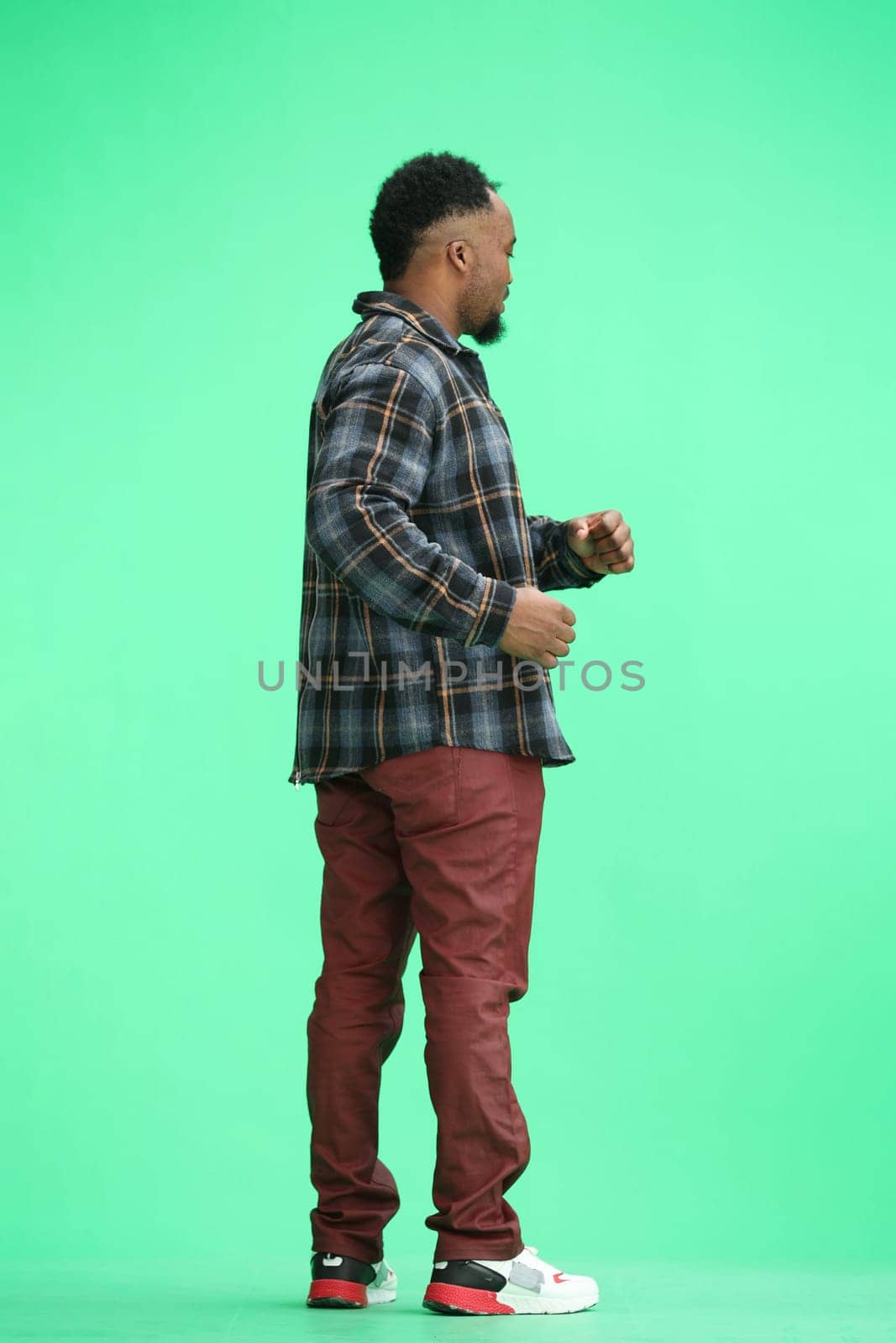 A man, full-length, on a green background, warming up by Prosto