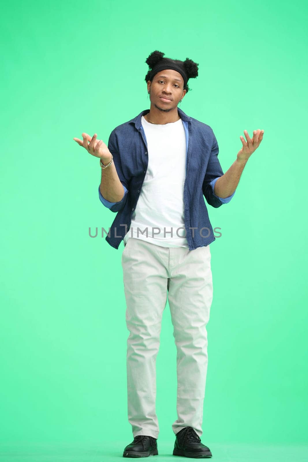 A man, full-length, on a green background, spreads his arms by Prosto