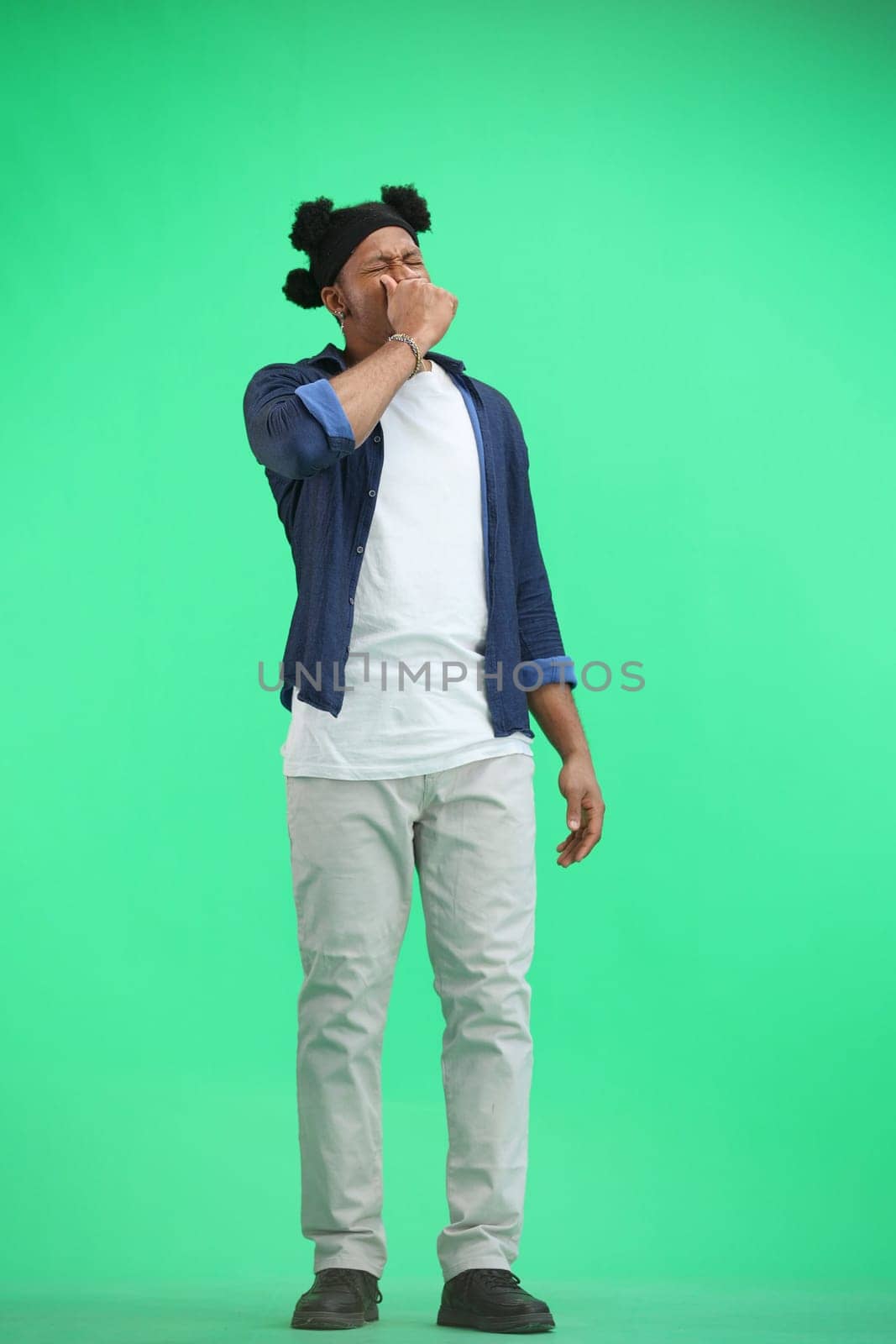 A man, full-length, on a green background, yawns by Prosto