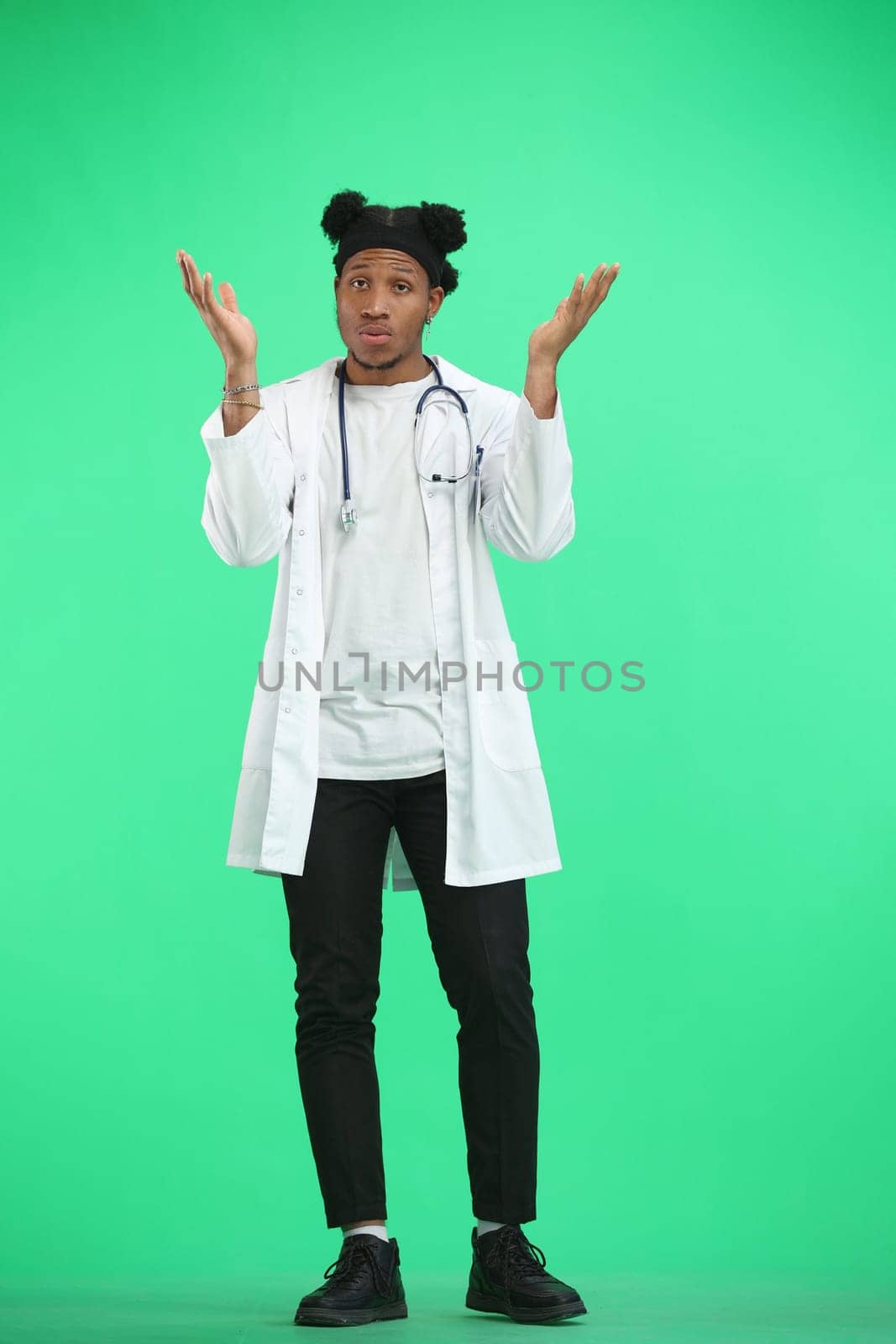 The doctor, in full height, on a green background, spreads his hands by Prosto