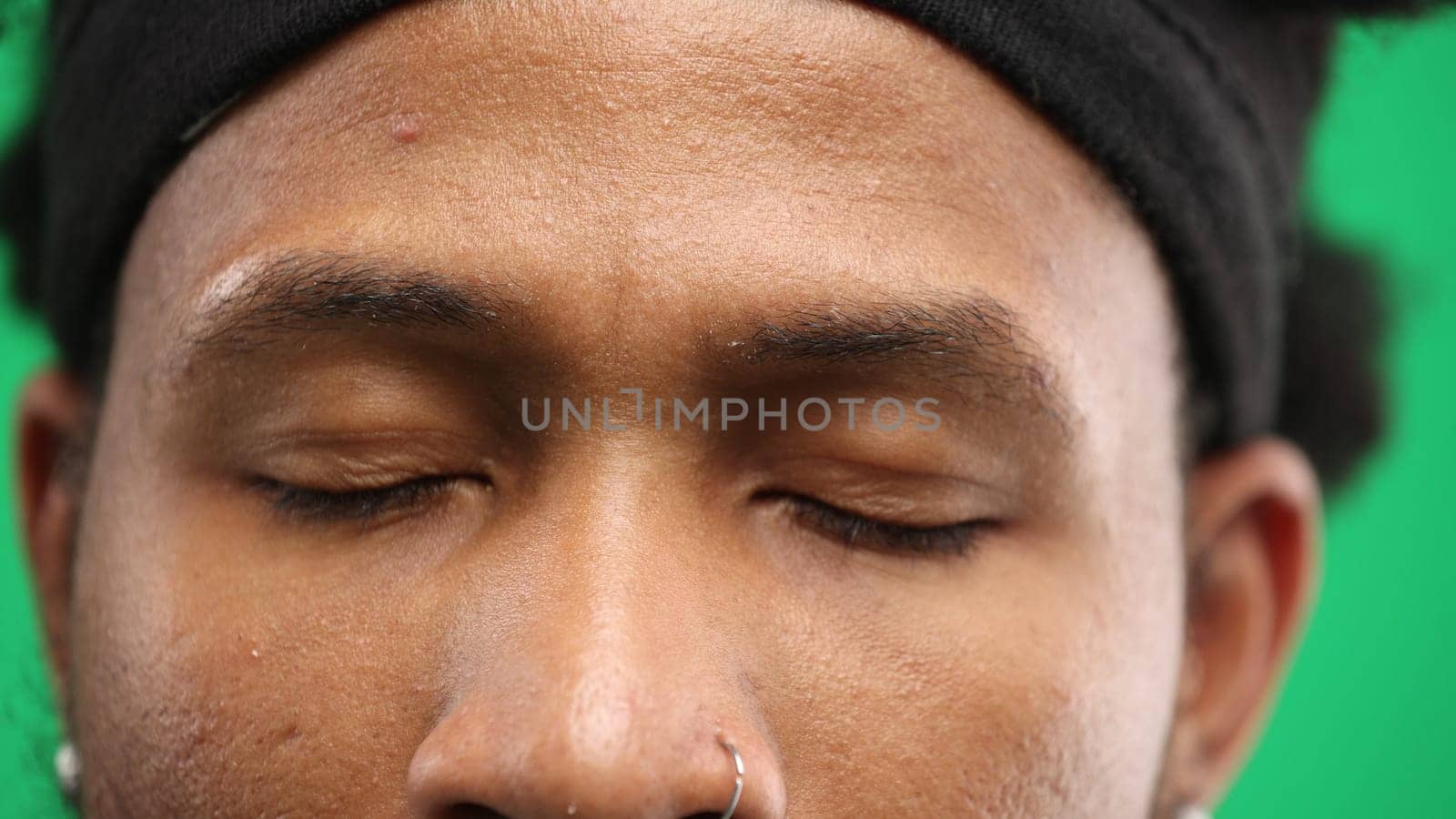 Man's eyes, close-up, on a green background.