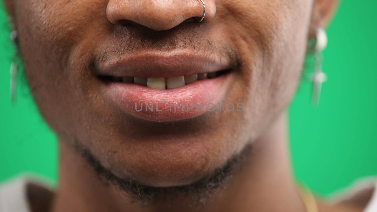 Man's mouth, close-up, on a green background by Prosto
