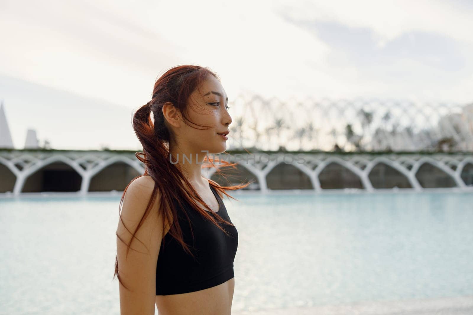 Female athlete in sportswear have a rest after morning jogging outside and looks away by Yaroslav_astakhov