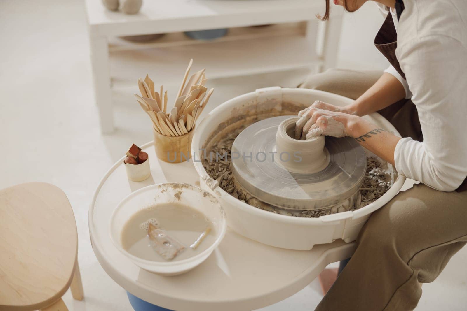 Close up of artisan's hands shaping clay bowl in pottery studio. Pottery art and creativity