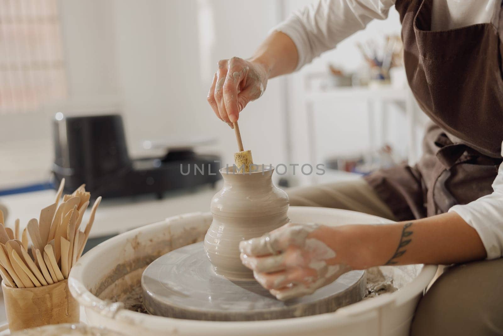 Close up of artisan's hands shaping clay bowl in pottery studio. Pottery art and creativity by Yaroslav_astakhov