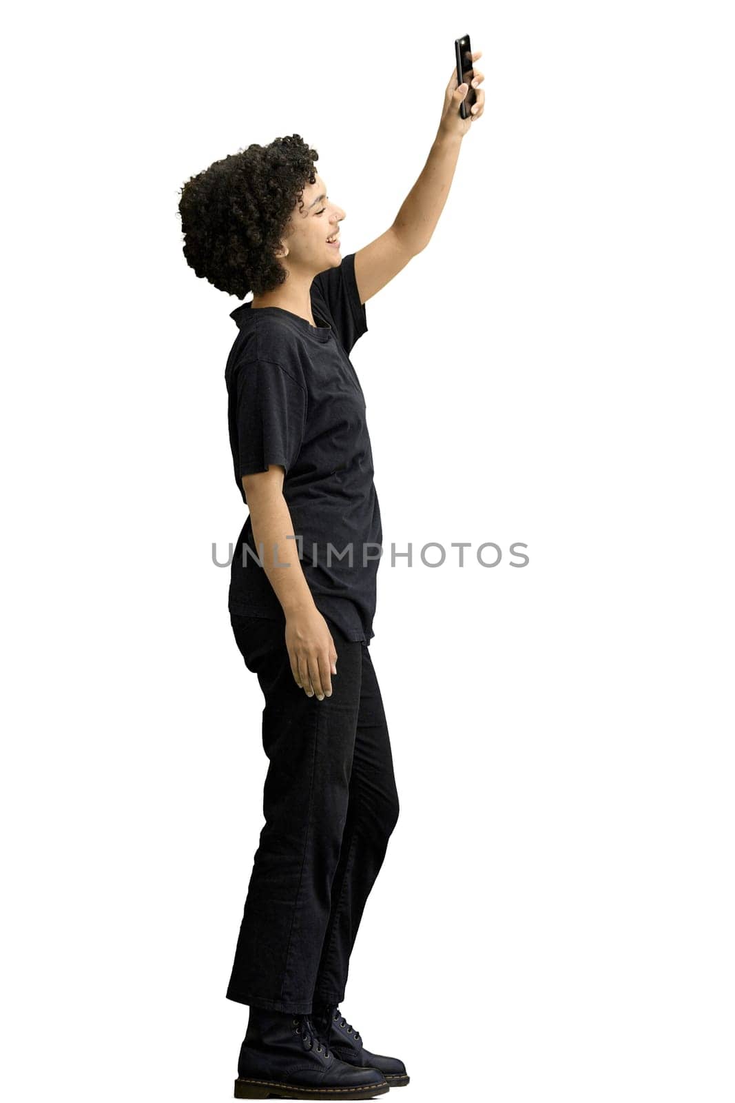 A woman, full-length, on a white background, waving her phone.