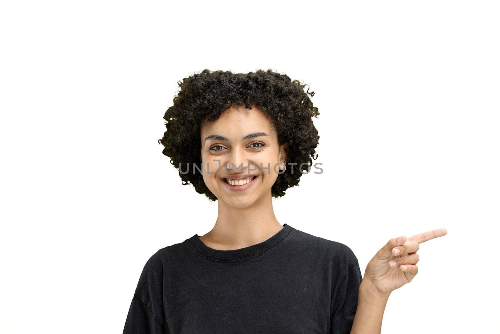 A woman, close-up, on a white background, points to the side.